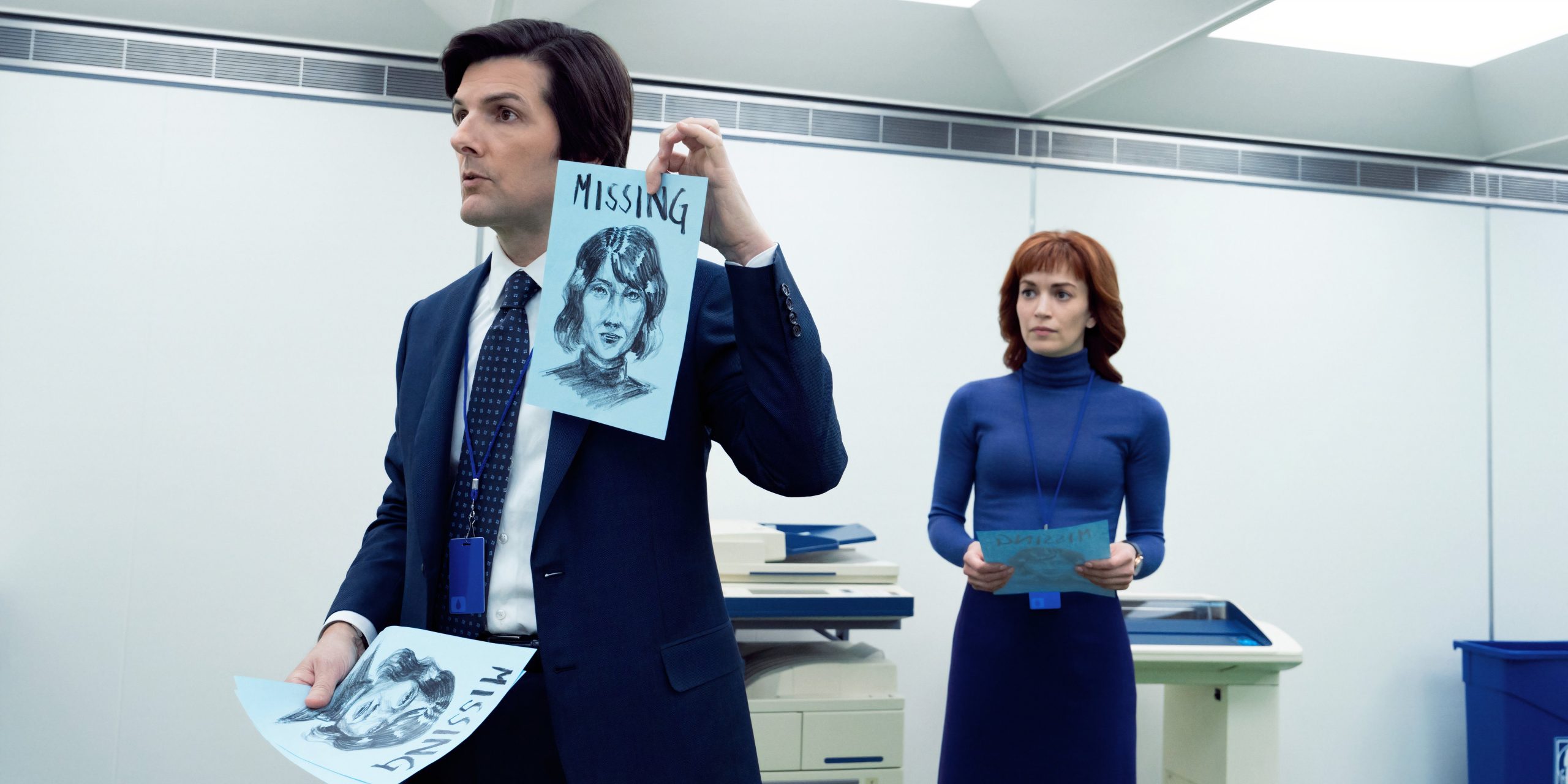 Mark (Adam Scott) tenant un avis de recherche, accompagné d'Helly (Britt Lower) dans Severance - Saison 2 épisode 3