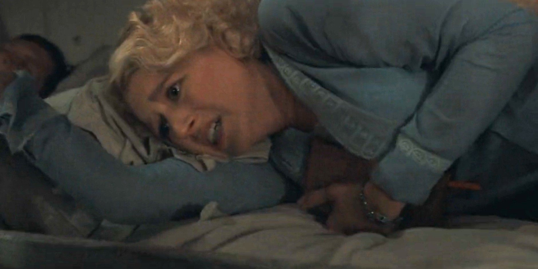 Alexandra Dutton (Julia Schlaepfer) semble terrifiée alors qu'elle s'accroche à un oreiller dans 1923 saison 2, épisode 2.