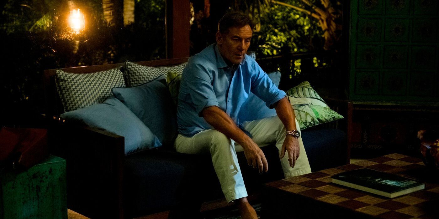 Jason Isaacs dans le rôle de Timothy tenant un verre et l'air triste dans The White Lotus Saison 3, Épisode 5.
