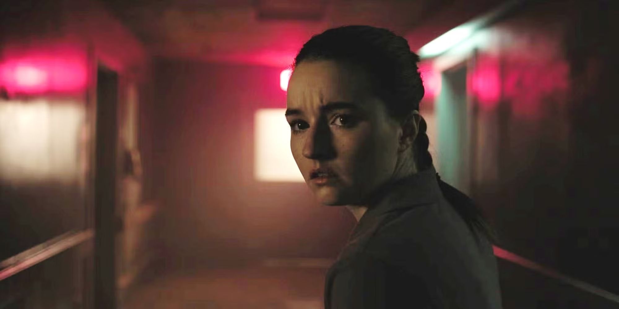 Kaitlyn Dever dans le rôle d'Abby, l'air inquiète à l'hôpital Firefly lors d'un flashback sur le massacre de Joel dans une scène de flashback de la saison 2 de The Last of Us.