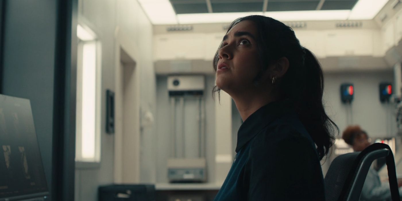 Geraldine Viswanathan dans le rôle de Mel, regardant nerveusement le plafond depuis son bureau d'ordinateur.