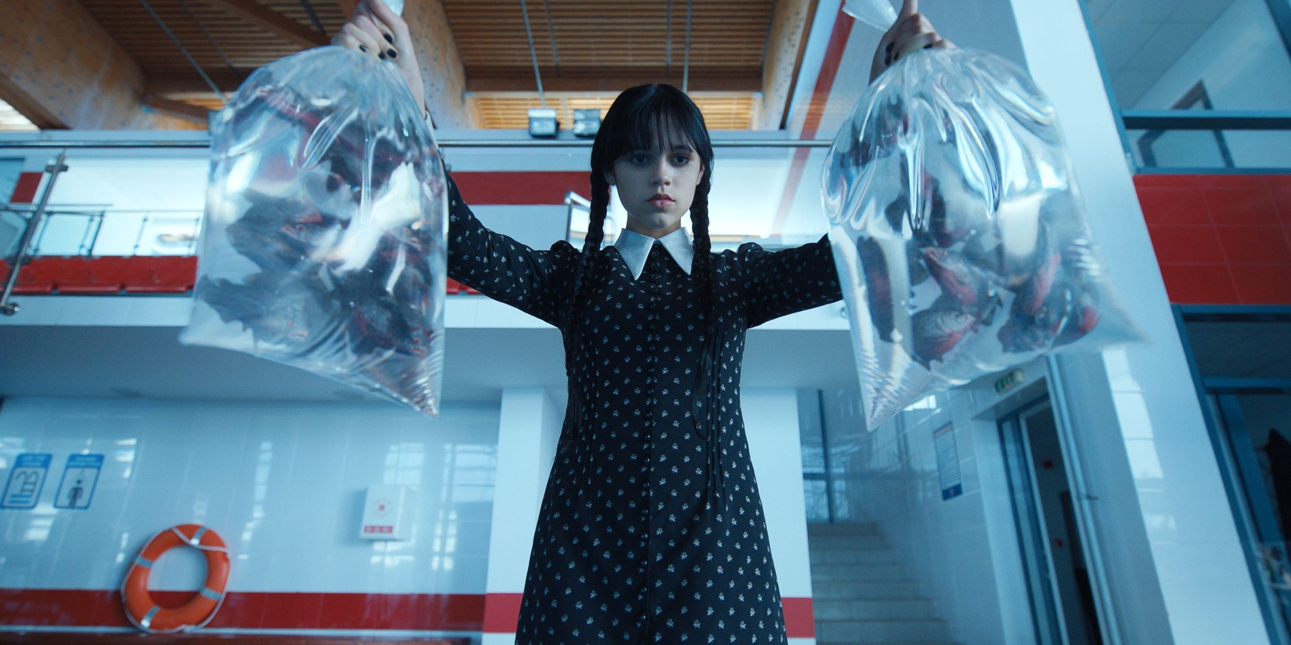 Mercredi (Jenna Ortega) jetant des piranhas dans la piscine de l'école, dans la saison 1 de Mercredi.