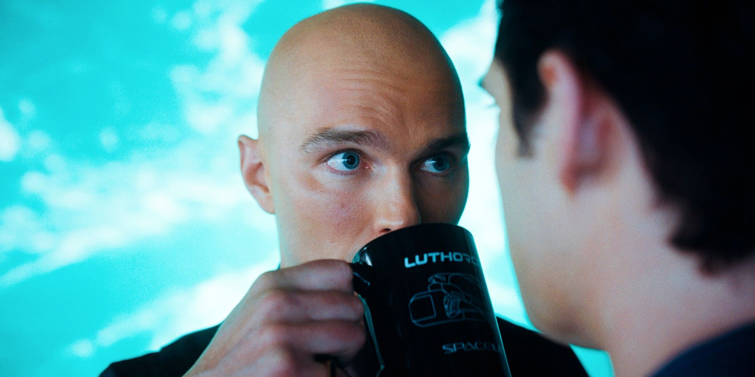 Lex Luthor (Nicholas Hoult) buvant son café en fixant Superman (David Corenswet).