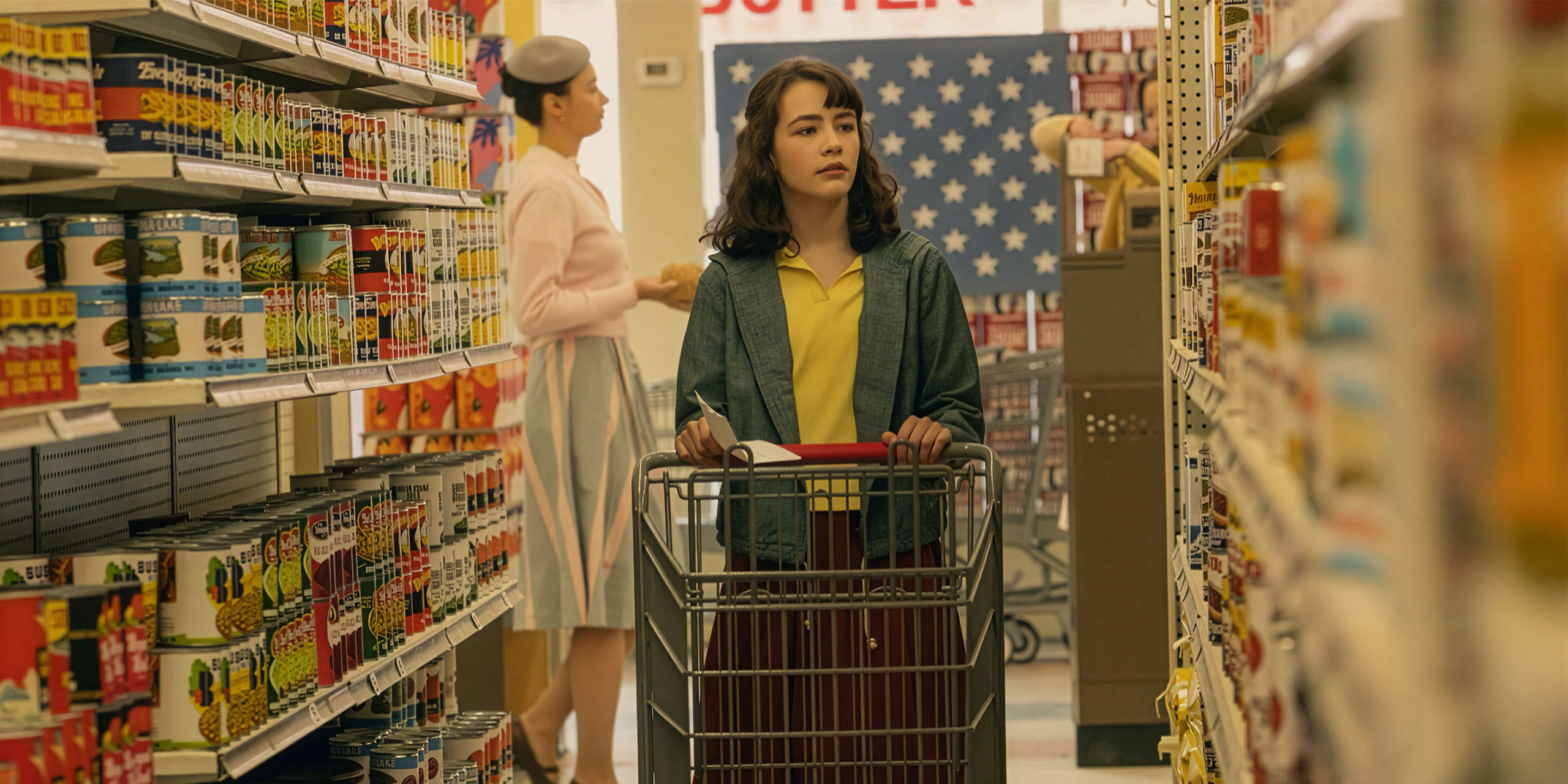 Lilly (Clara Stack) a l'air poussant un caddie dans une épicerie dans Ça : Bienvenue à Derry.