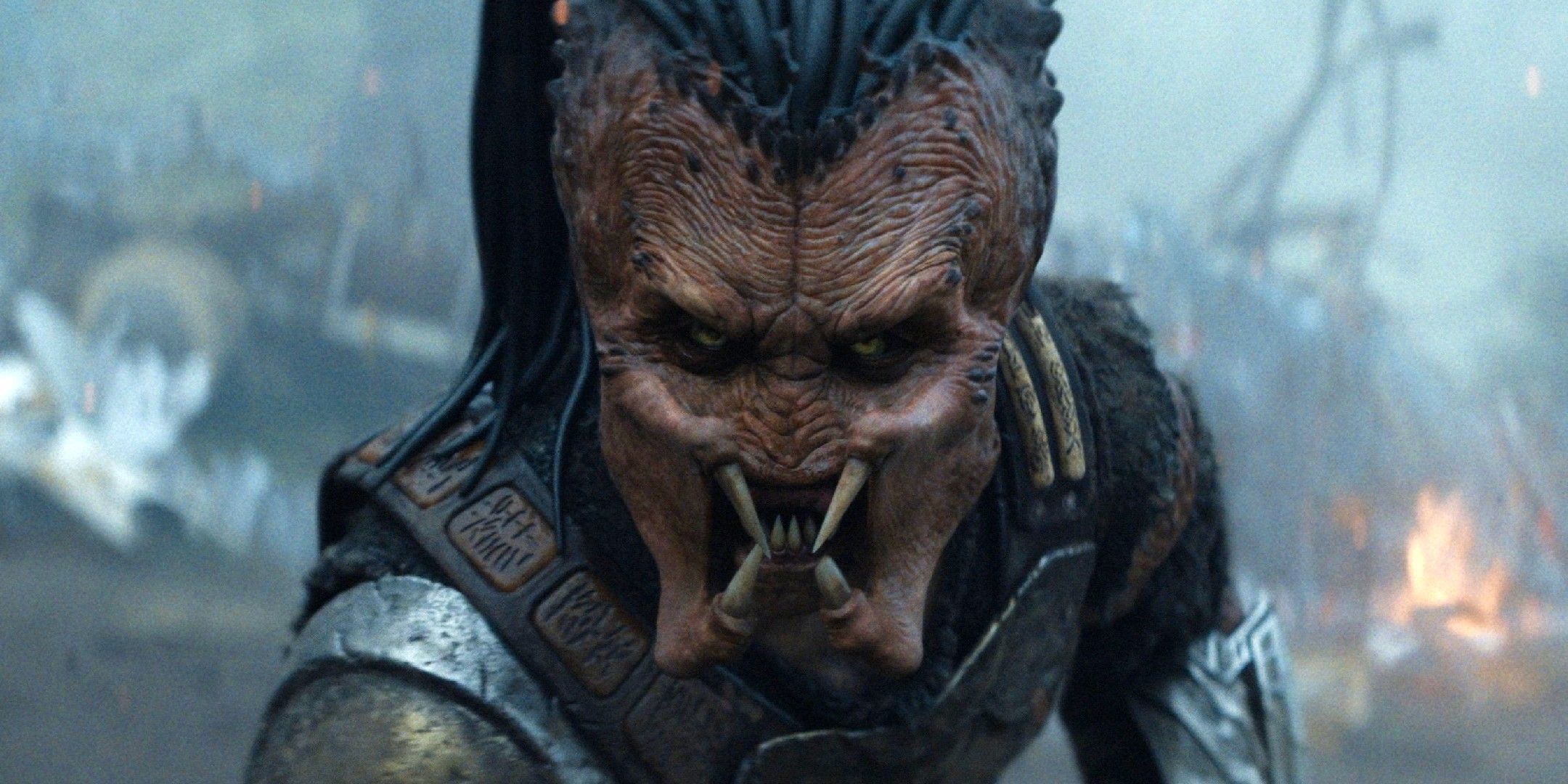 Predator: Badlands - Gros plan intense du Predator Dek, gueule ouverte, montrant ses crocs. Le visage du Yautja et son armure, tirés de la bande-annonce officielle du film de Dan Trachtenberg.