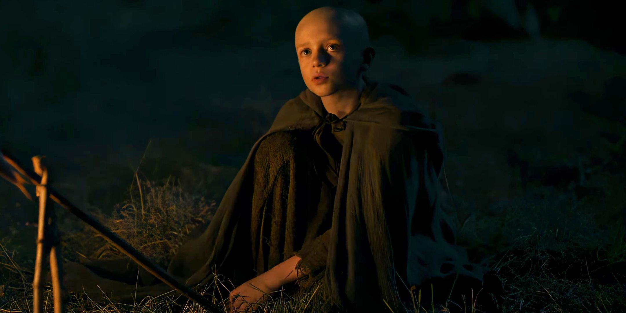 Egg (Dexter Sol Ansell) regarde avec curiosité assis à côté d'un feu dans A Knight of the Seven Kingdoms