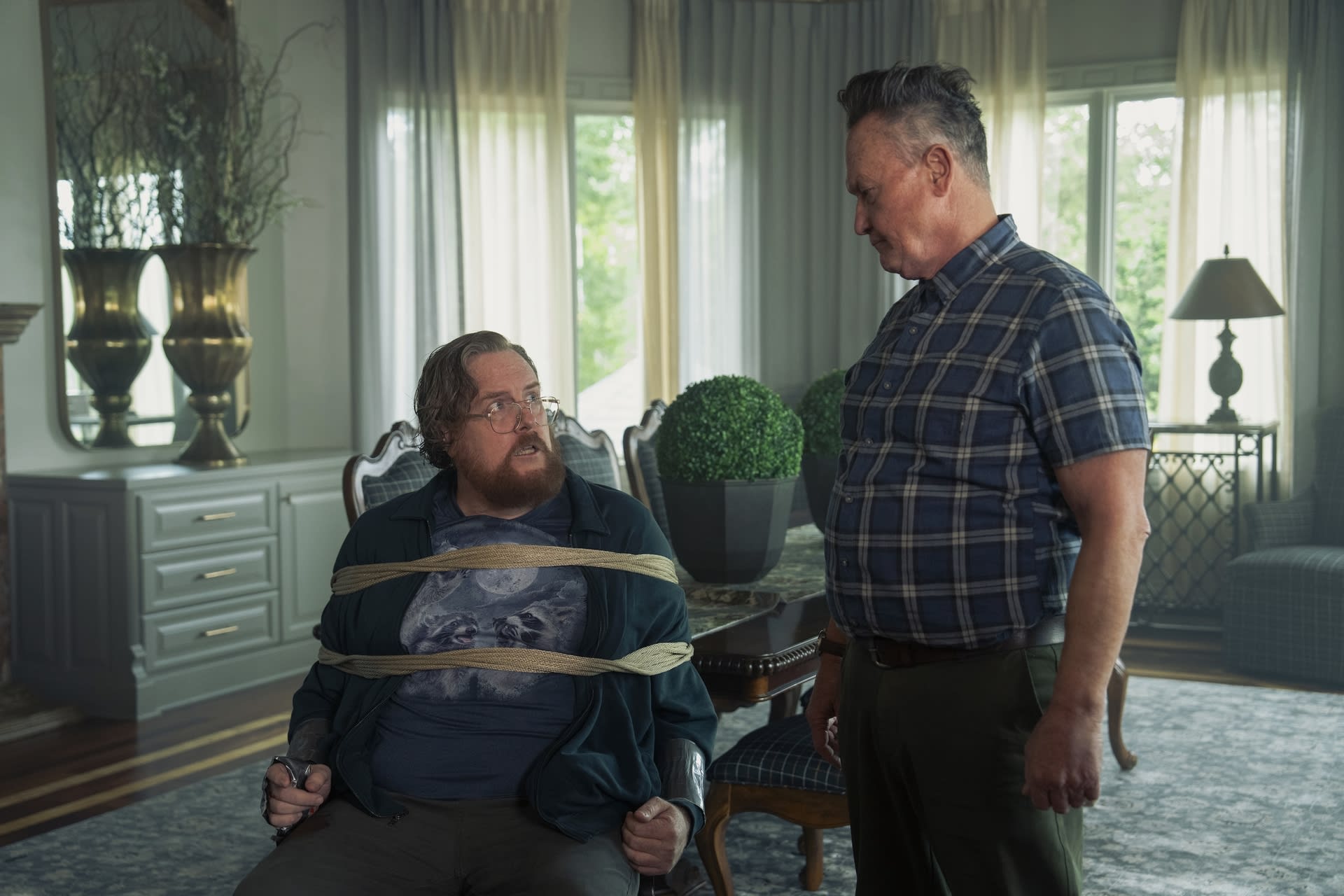 Economos (Steve Agee) prisonnier par le père de Chris (Robert Patrick) dans l'univers alternatif Terre-X dans l'épisode7 de la saison 2 de Peacemaker.
