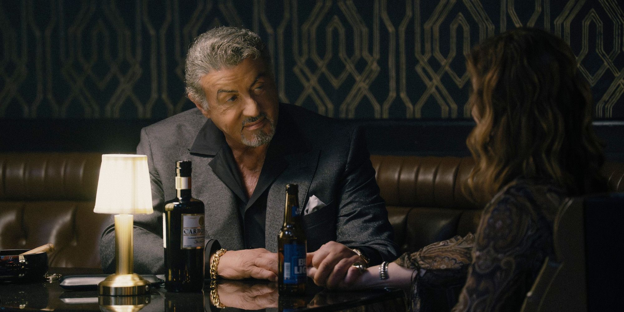 Sylvester Stallone parle à Dana Delaney lors d'un dîner intime dans une scène de Tulsa King