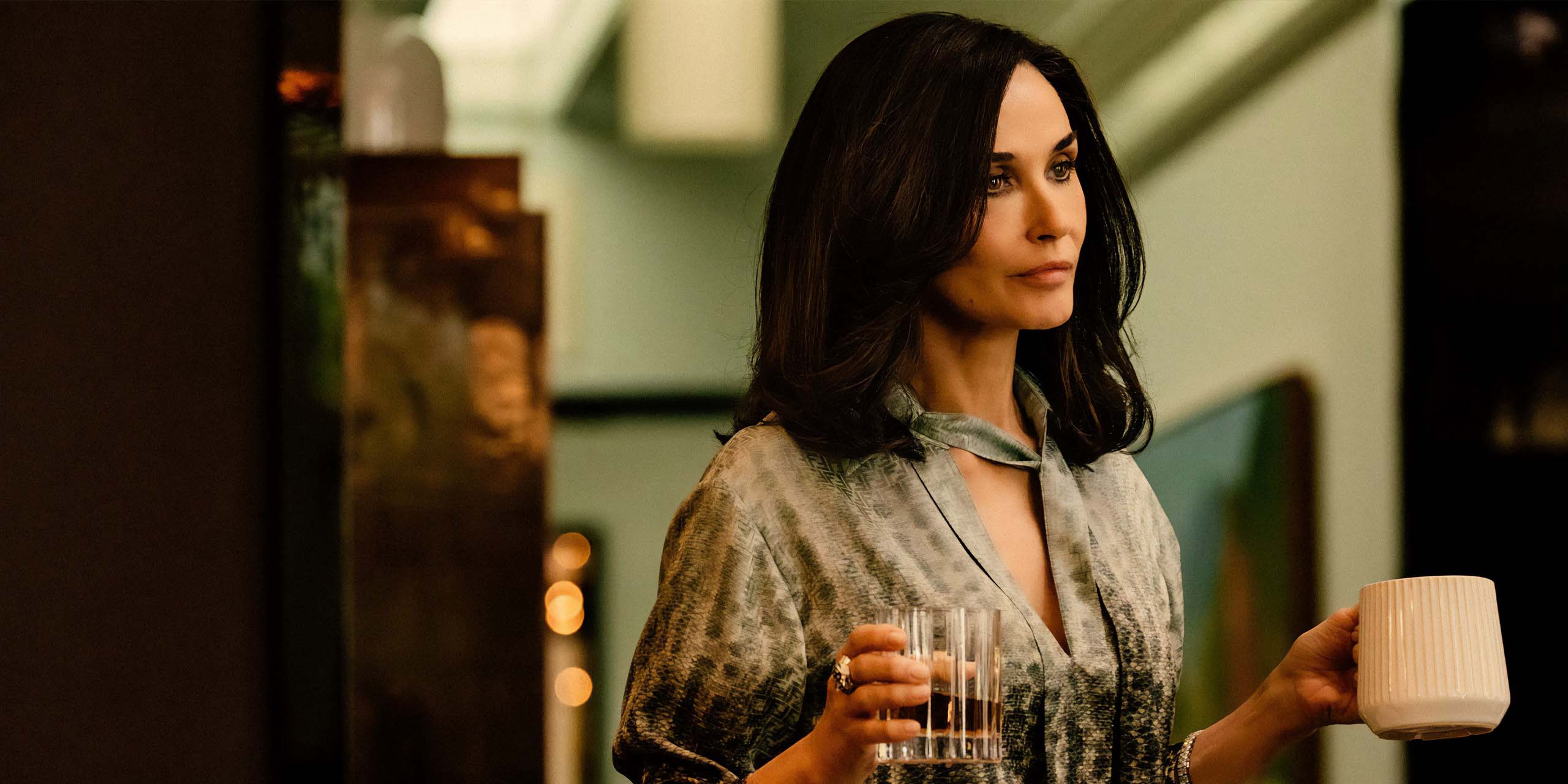 Cami Miller (Demi Moore) tenant un verre de whisky et une tasse de café dans Landman.