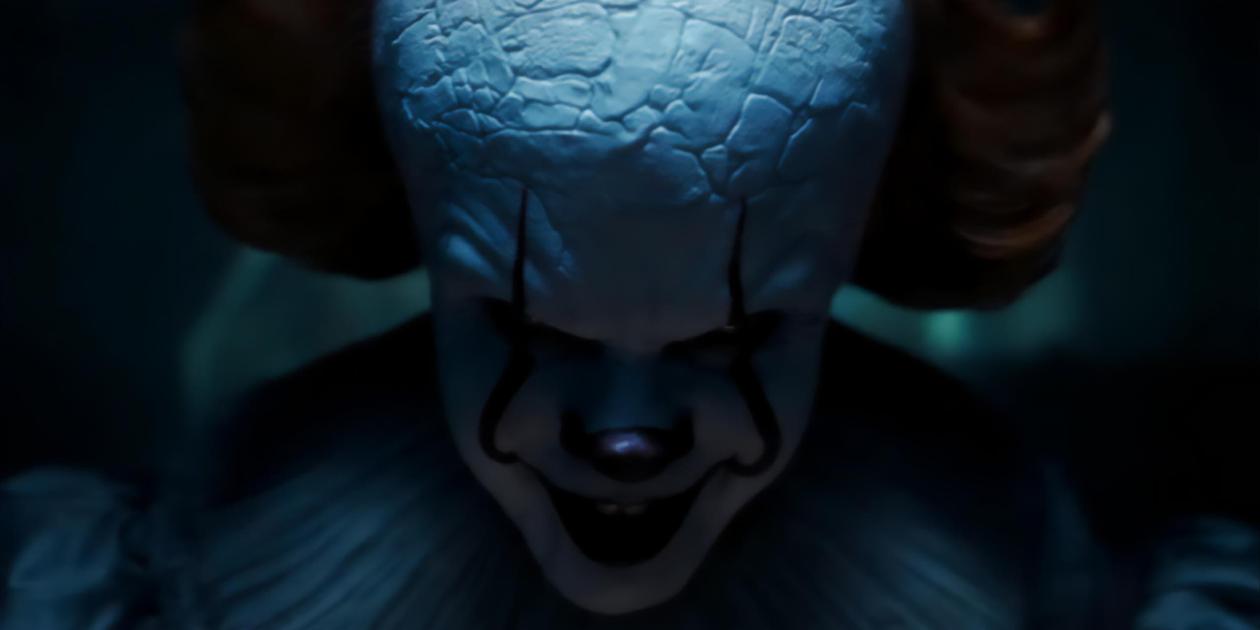 Ça : Bienvenue à Derry épisode 4 origines Pennywise : Le clown Pennywise ( Bill Skarsgård) tenant un ballon en souriant dans la série HBO Max.