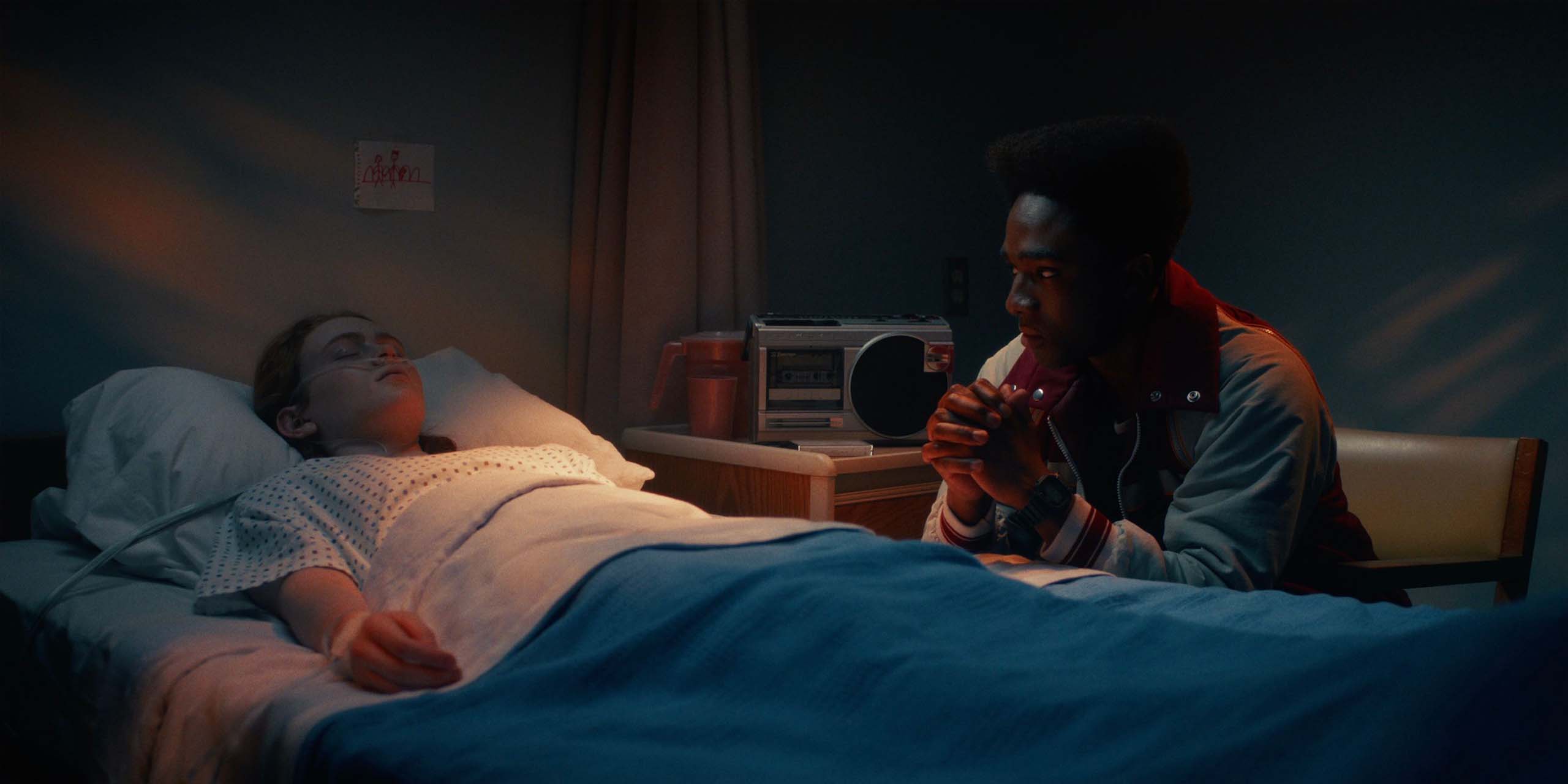 Lucas au chevet de Max à l'hôpital dans Stranger Things.