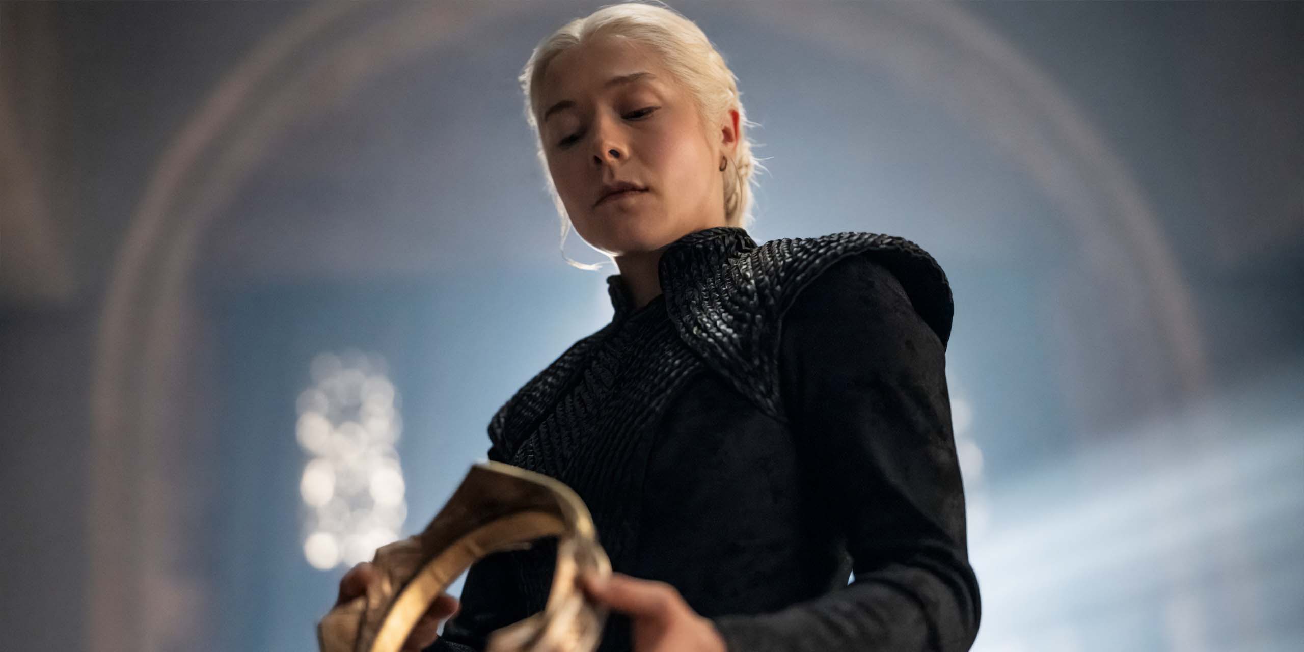 Emma D'Arcy, dans le rôle de Rhaenyra Targaryen, contemple sa couronne dans la saison 3 de House of the Dragon.