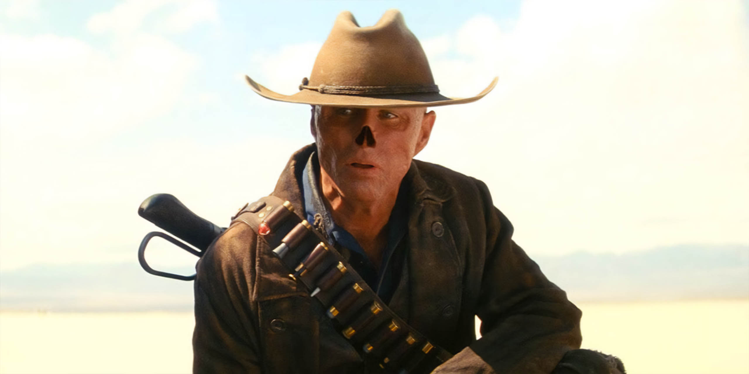 Walton Goggins dans le rôle de la Goule, un personnage à la peau rouge et sans nez, portant un chapeau de cow-boy dans Fallout.
