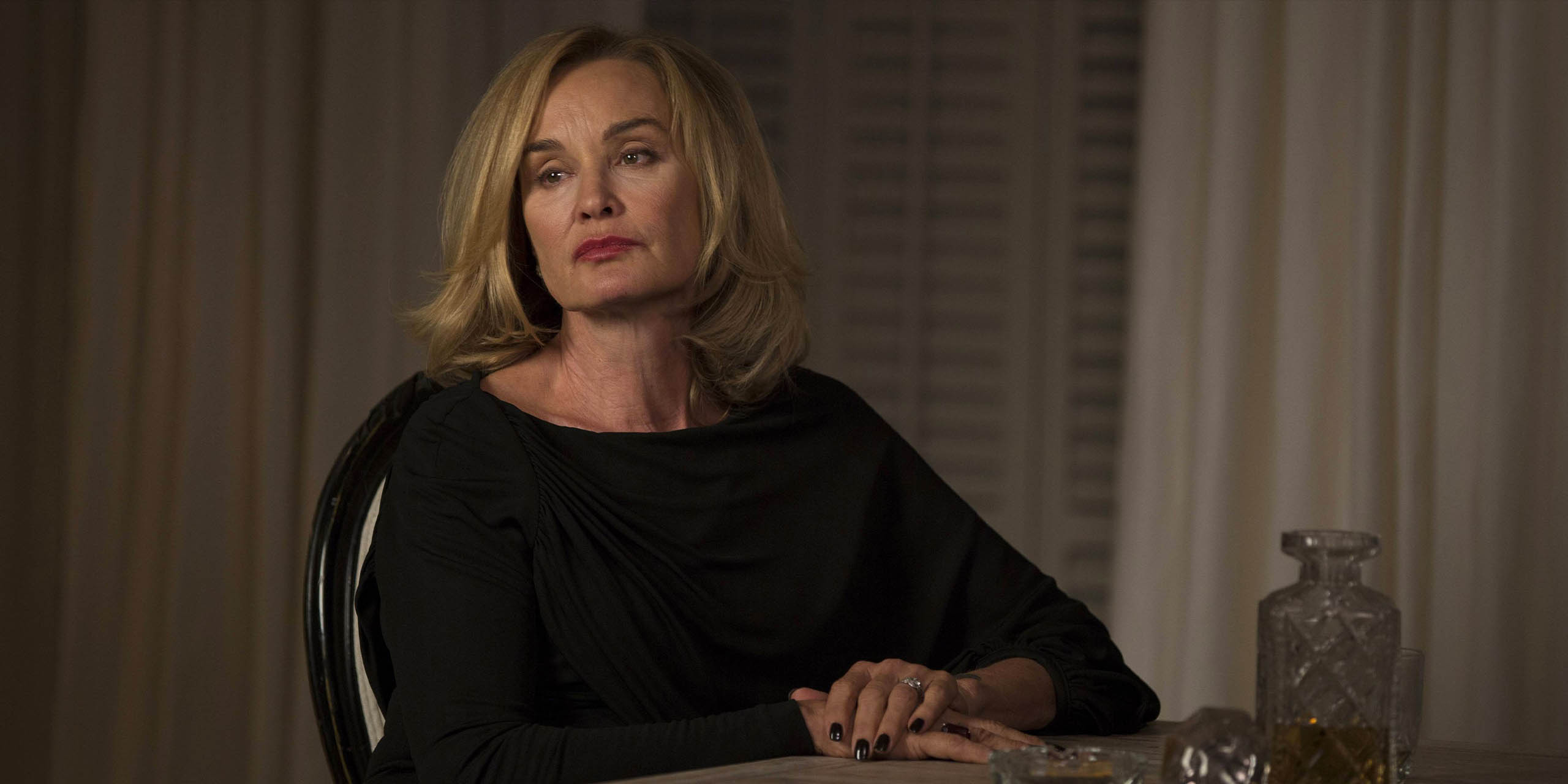 Fiona (Jessica Lange) assise à une table dans American Horror Story: Coven.