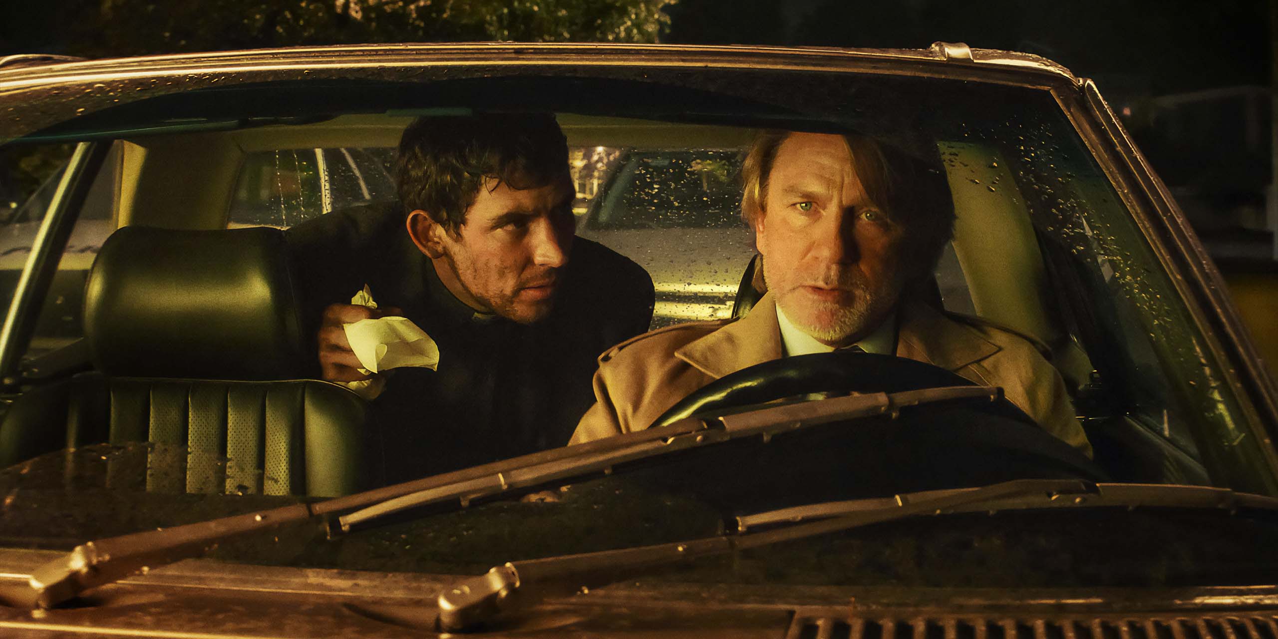 Le détective privé Benoit Banc (Daniel Craig) et le père Jud Duplenticy (Josh O'Connor) dans une voiture dans le film Wake-Up Dead Man de Rian Johnson sur Netflix.
