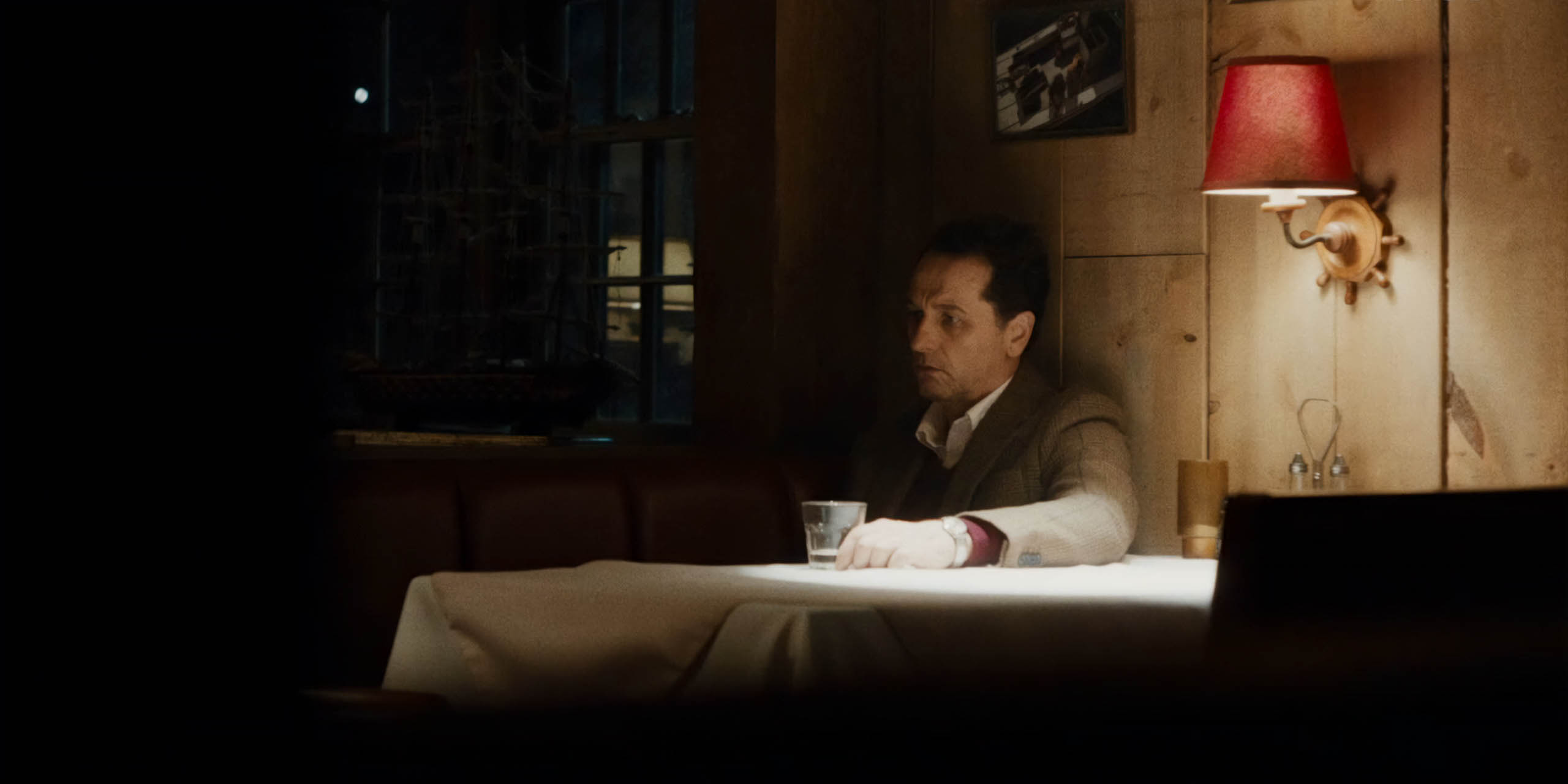 Le maire Tom Loftis (Matthew Rhys) assis à une table dans Widow's Bay d'Apple TV+.