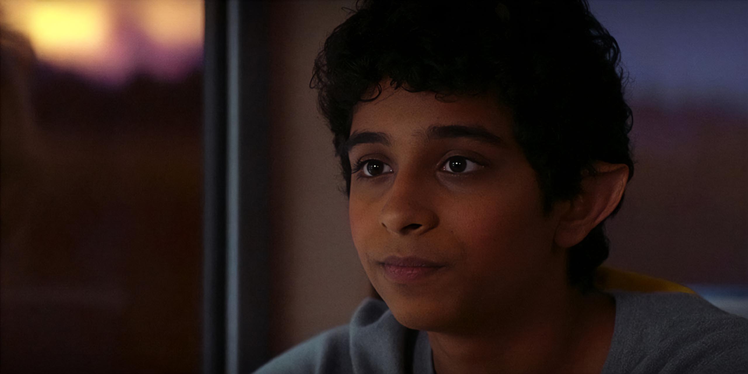 Aryan Simhadri, dans le rôle de Grover, a l'air triste à bord d'un train dans Percy Jackson.