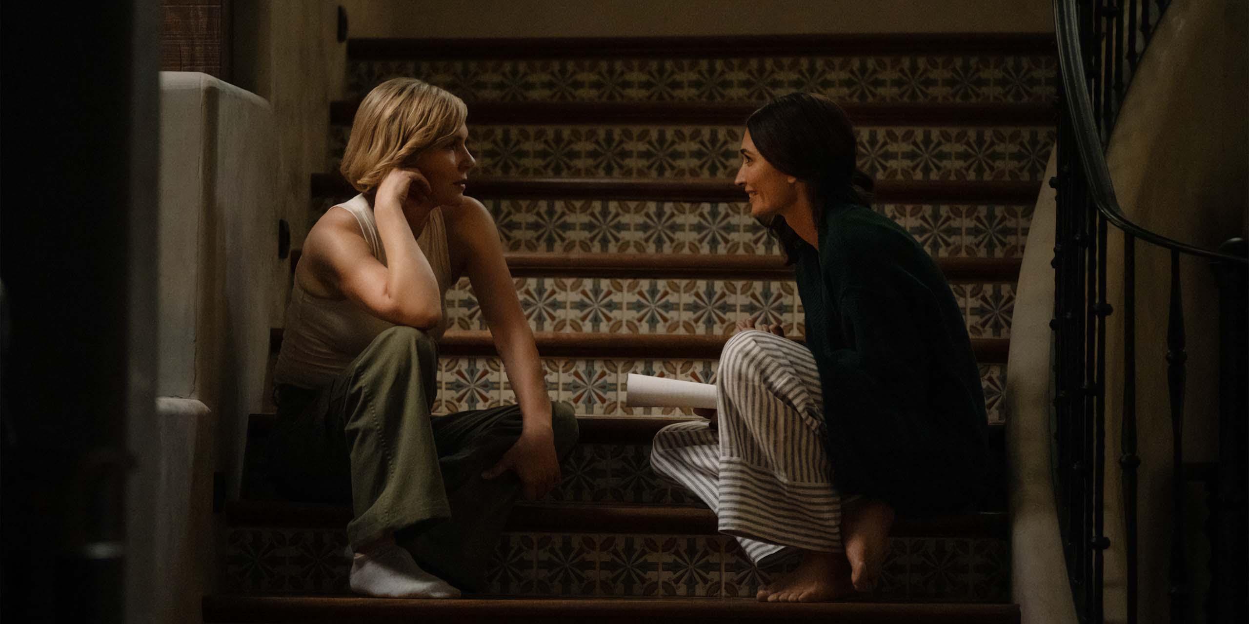 Carol (Rhea Seehorn) et Zosia (Karolina Wydra) discutent assis dans les escaliers dans Pluribus.