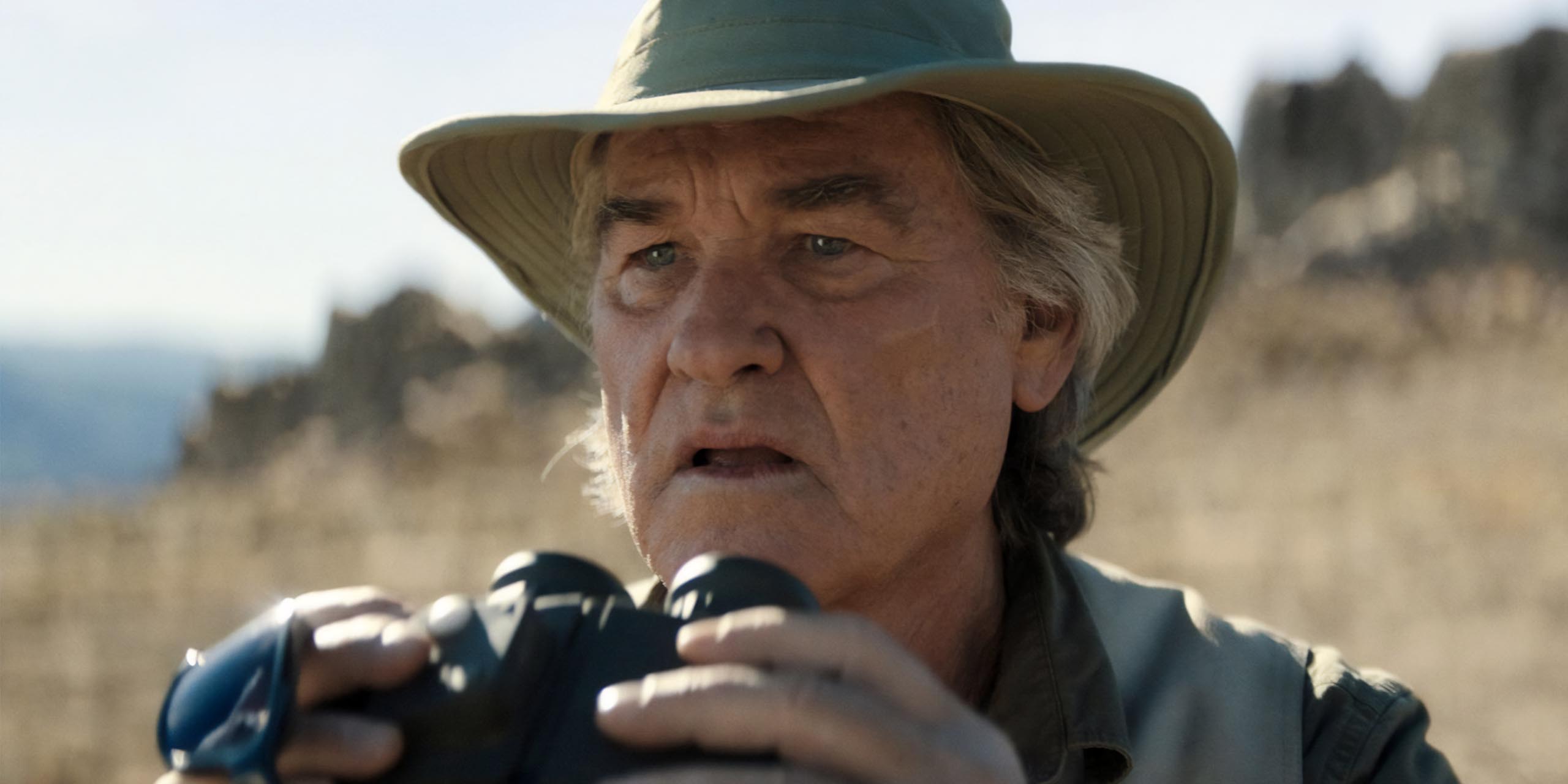 Kurt Russell dans le rôle de Lee Shawn avec des jumelles dans Monarch: Legacy of Monsters..