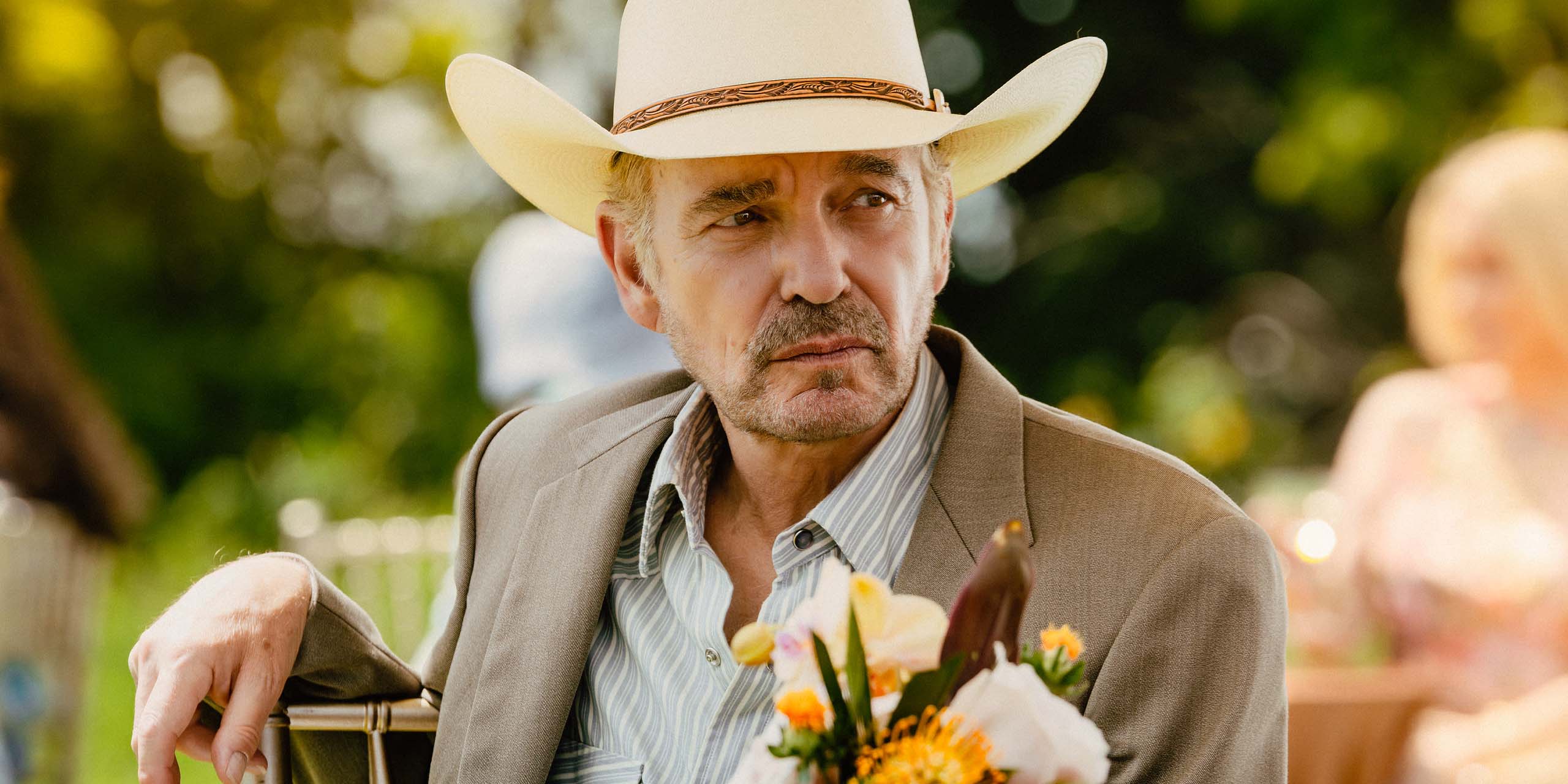 Tommy Norris (Billy Bob Thornton) assis à une table devant des fleurs dans l'épisode 9 de la saison 2 de Landman.