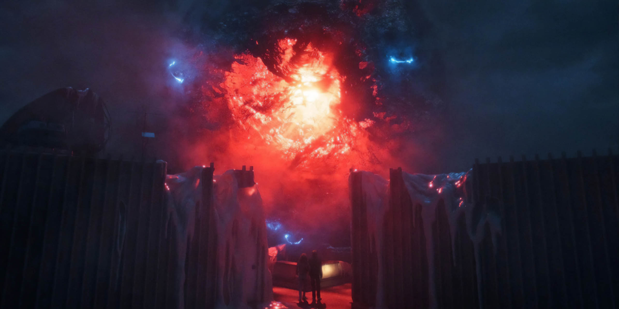 Une grosse boule rouge pulsante d'énergie flottante au-dessus du laboratoire Hawkins dans l'Upside Down, dans Stranger Things 5, Volume 2