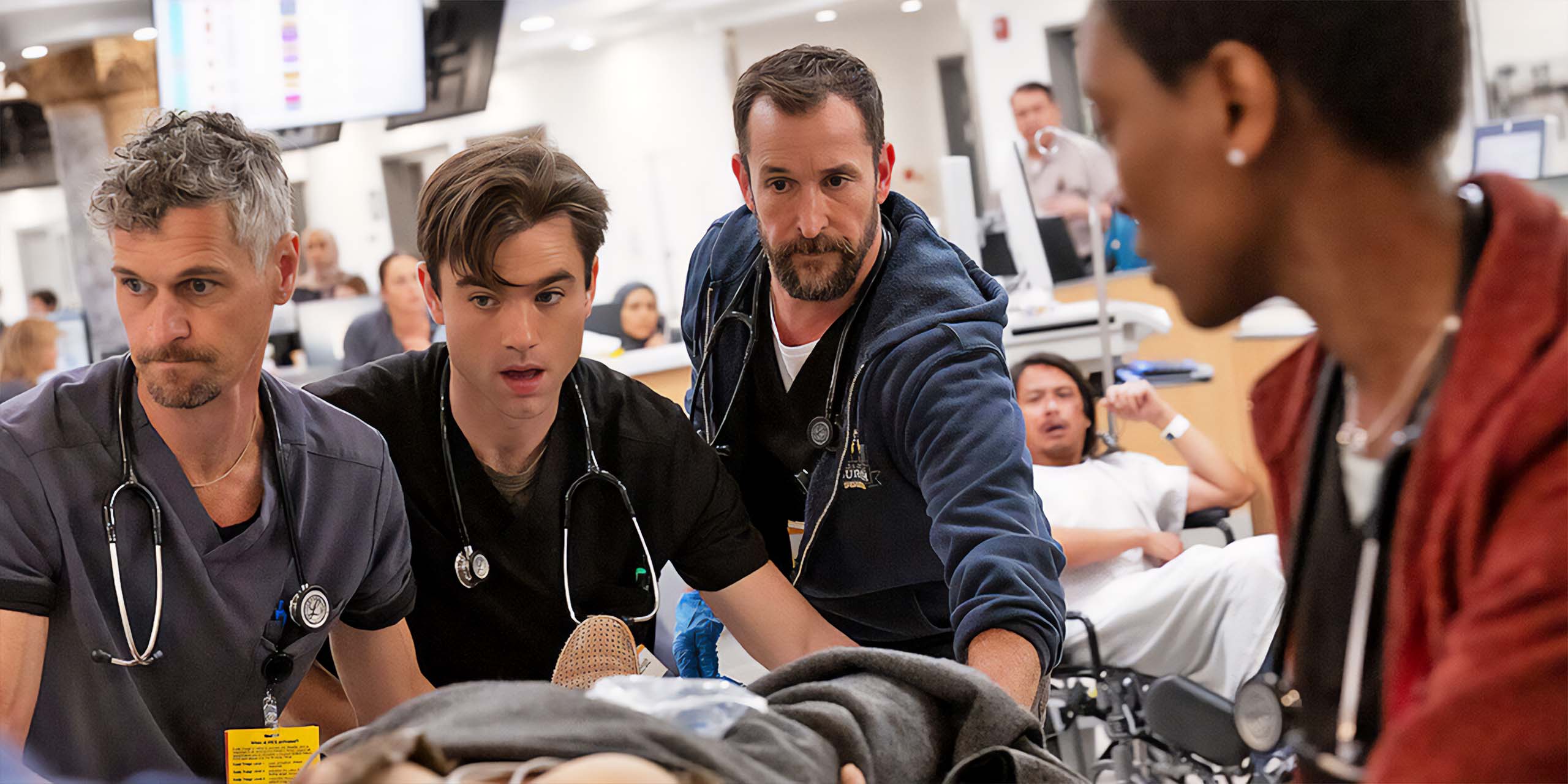 Noah Wyle, ausculté au stéthoscope, regarde sur le côté dans The Pitt.