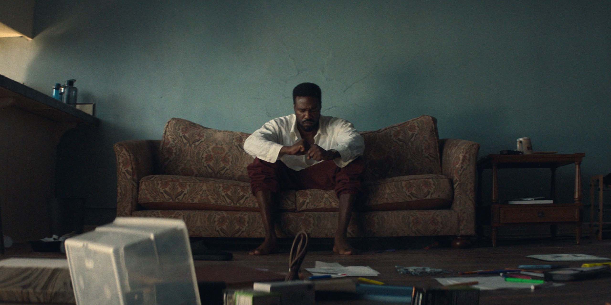 Simon Williams (Yahya Abdul-Mateen II) assis sur un canapé dans la série Wonder Man.