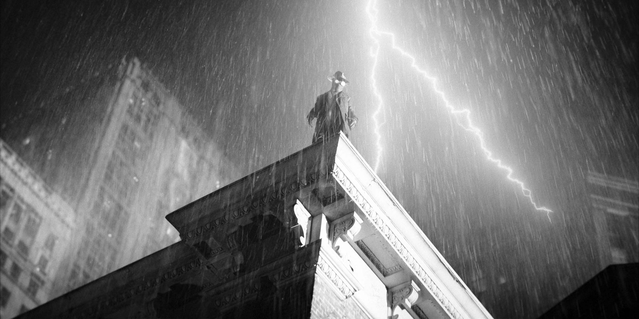 Nicolas Cage dans le rôle de Ben Reilly sur le toit dans Spider-Noir (version noir et blanc).