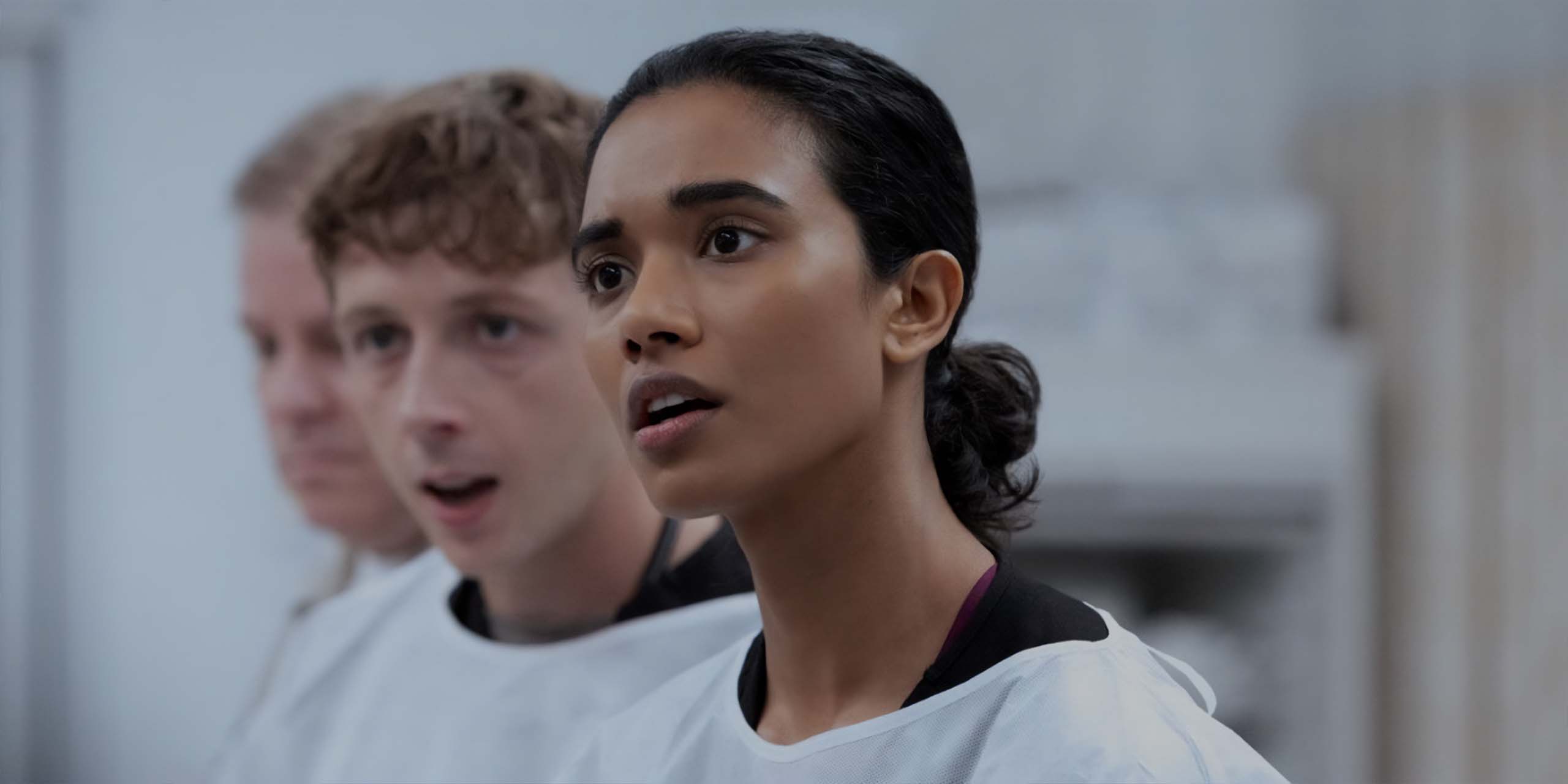 Dennis Whitaker (Gerran Howell) et le Dr Samira Mohan (Supriya Ganesh) portant des blouses blanches dans The Pitt.