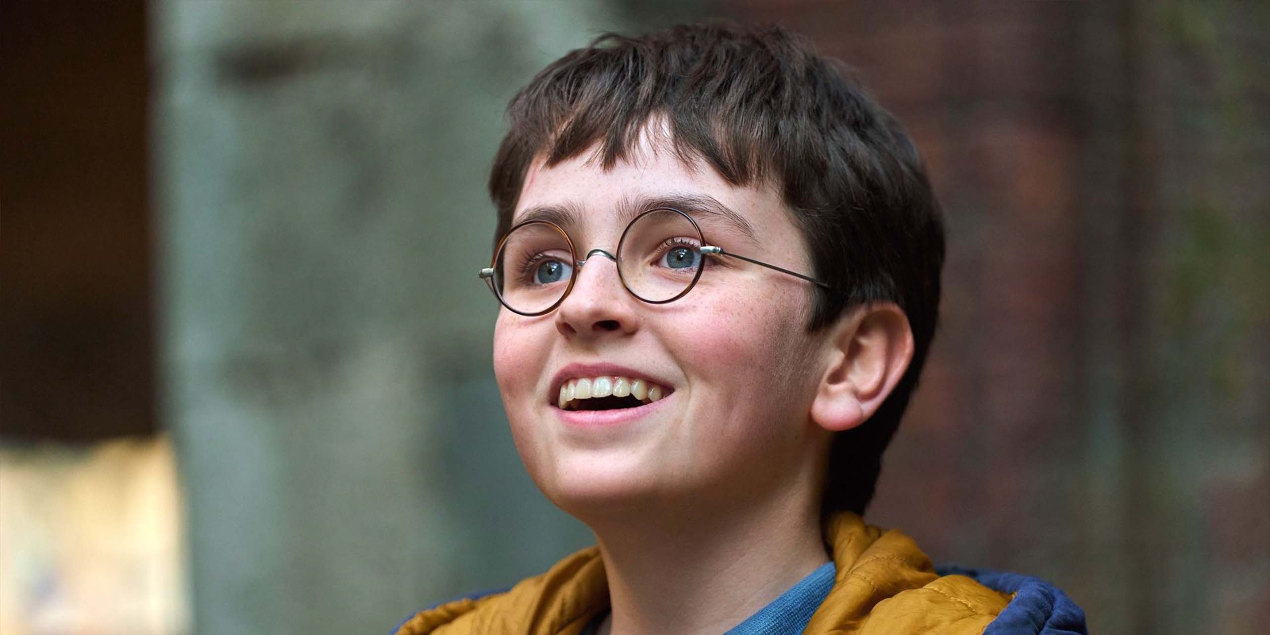 Dominic McLaughlin souriant dans le rôle de Harry Potter dans Harry Potter à l'école des sorciers