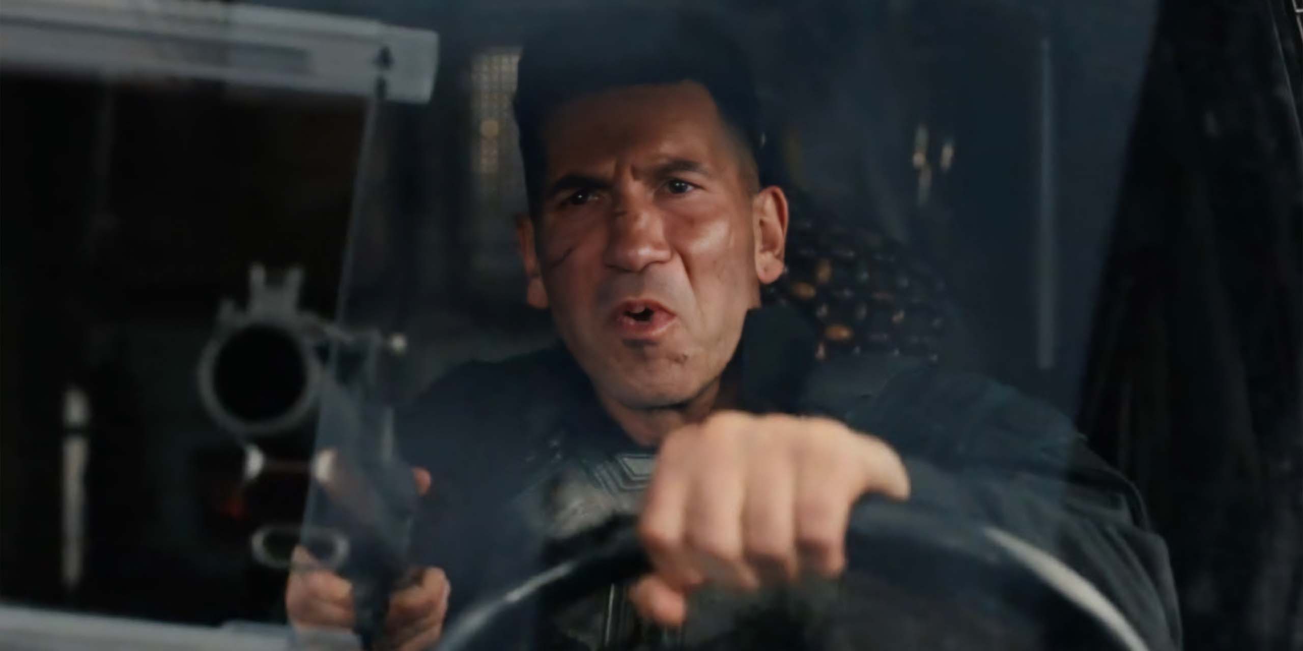 Frank Castle (Jon Bernthal) alias le Punisher, tenant un fusil au volant d'un véhicule dans Spider-Man: Brand New Day.
