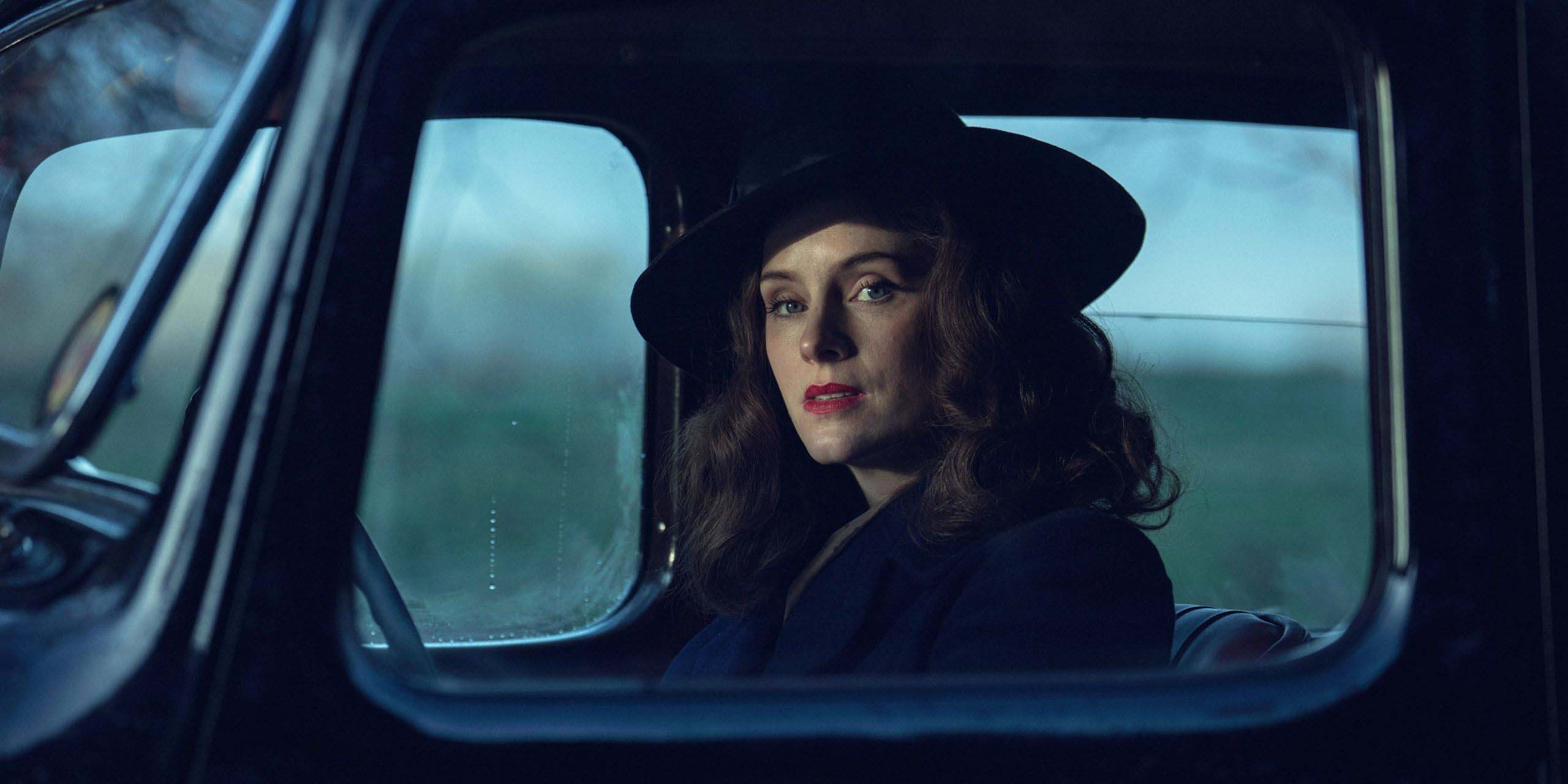 Sophie Rundle, dans le rôle d'Ada Shelby, conduit une voiture et regarde par la fenêtre dans Peaky Blinders: The Immortal Man.