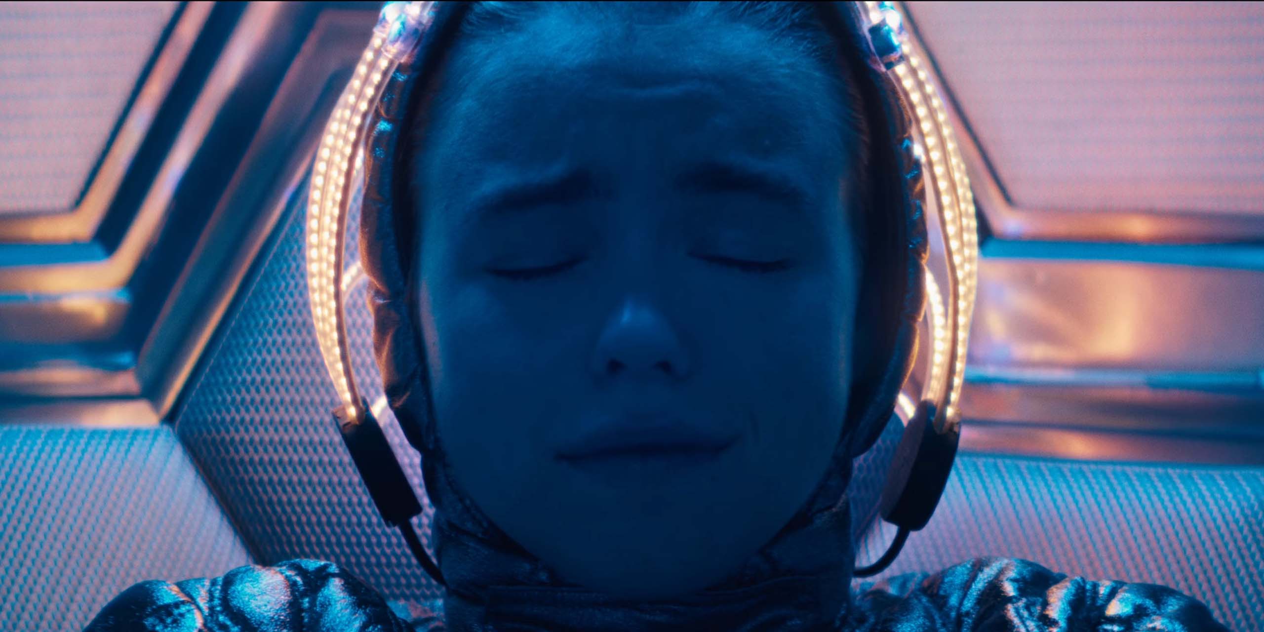 Kara (Milly Alcock) sur Krypton, alors que ses parents s'apprêtent à l'envoyer dans l'espace dans Supergirl.