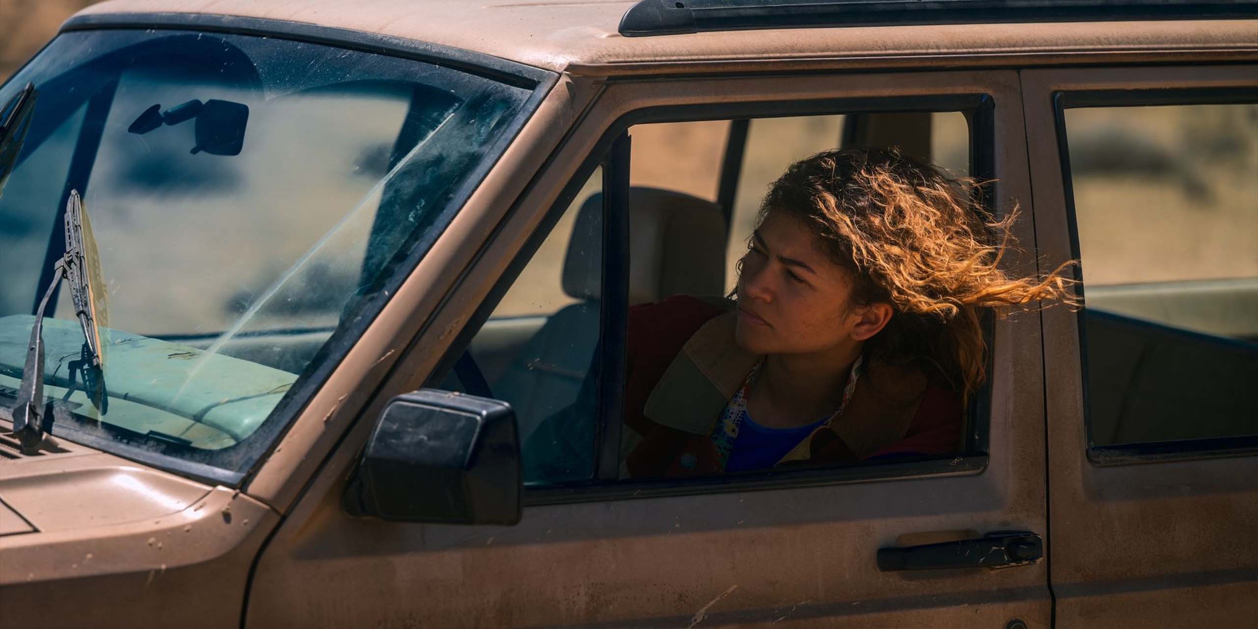Zendaya, dans le rôle de Rue, passe la tête par la fenêtre d'une voiture qui traverse le désert dans la saison 3 d'Euphoria.