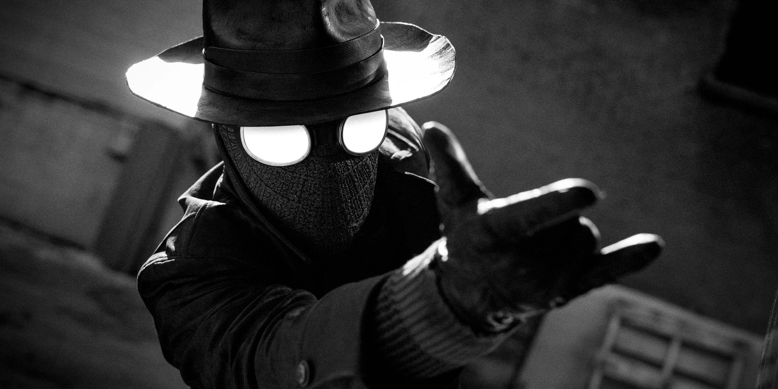 Ben Reilly (Nicolas Cage) dans son costume de Spider-Noir et lançant des toiles d'araignée.