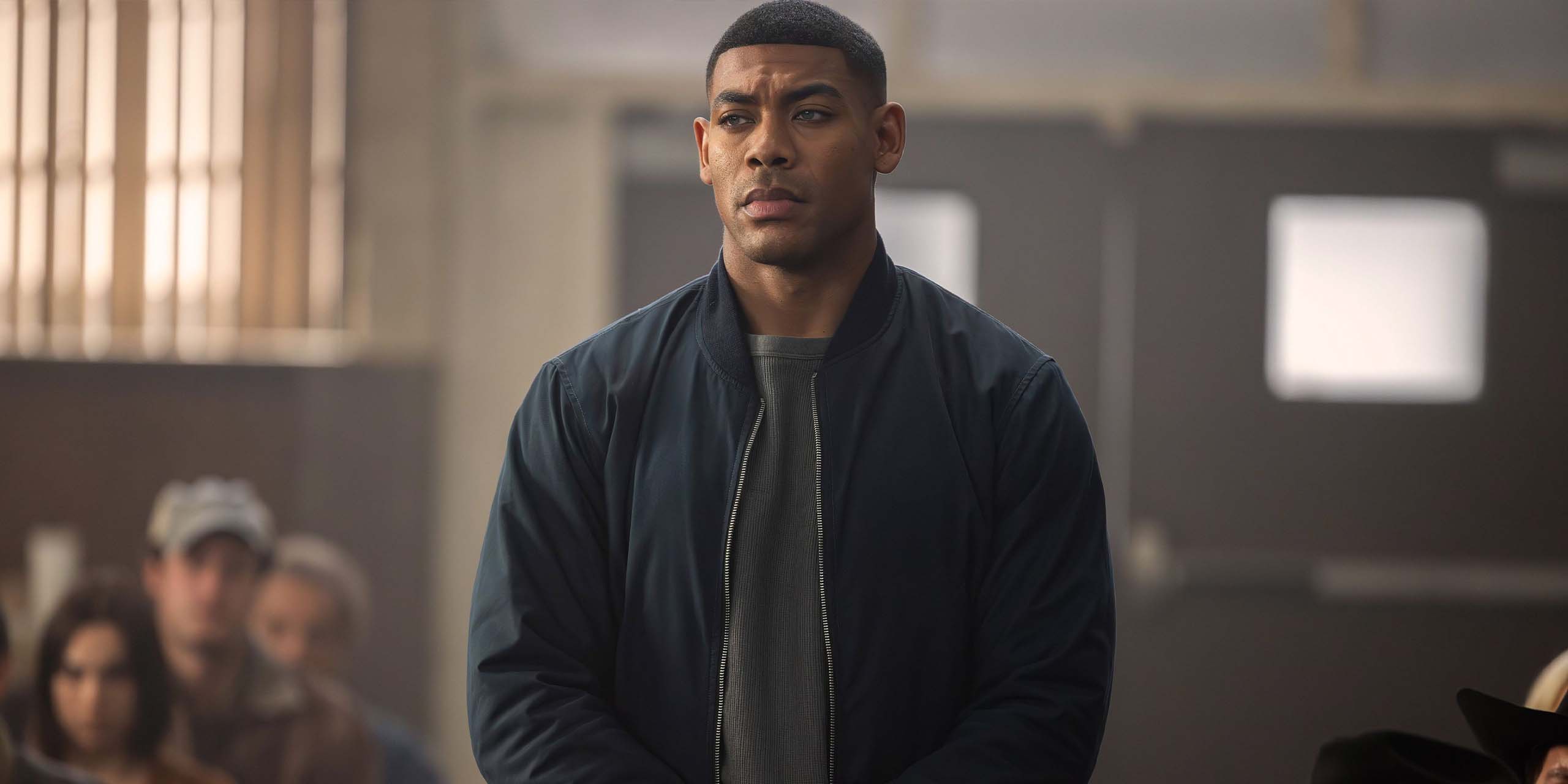Aaron Pierre se tient debout dans une salle d'audience dans la série Lanterns.