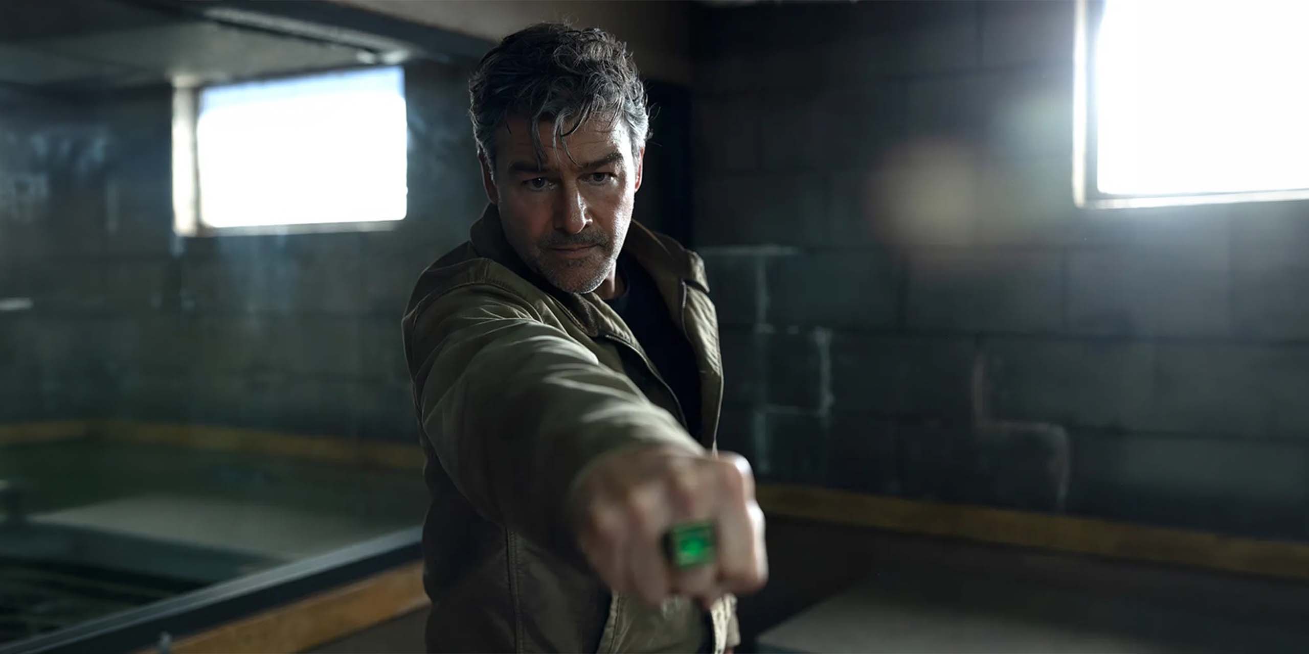 Kyle Chandler dans le rôle de Hal Jordan, pointant son anneau de Green Lantern dans Lanterns
