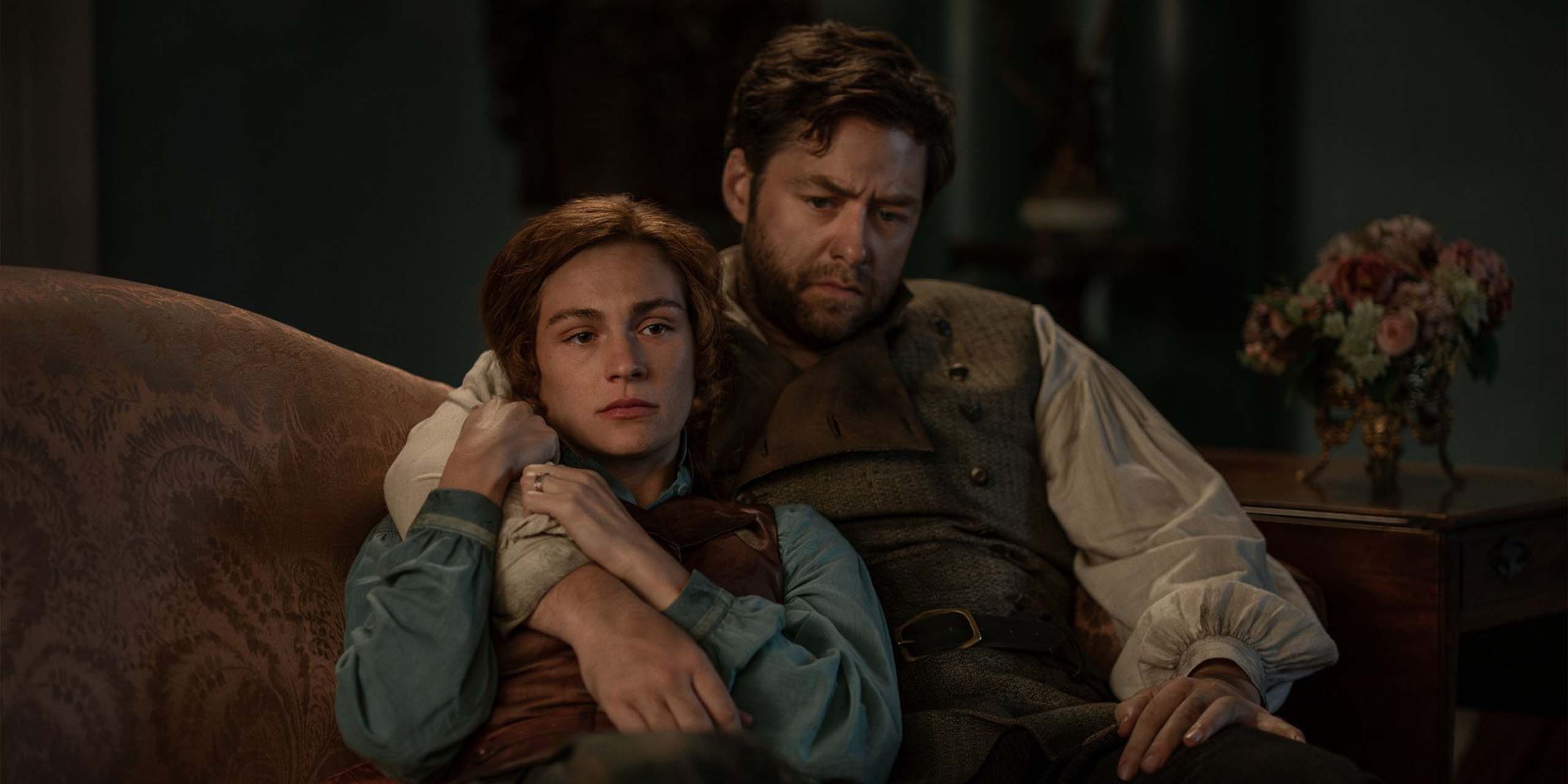Roger et Brianna, assis côte à côte, le visage noirci et dévasté, dans la saison 8 d'Outlander