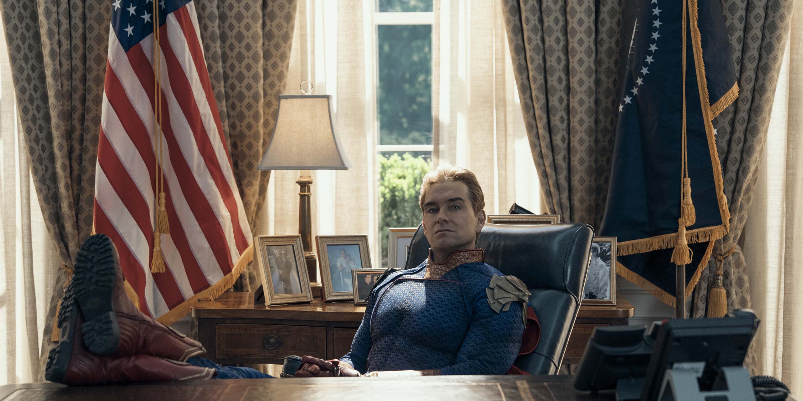 Anthony Starr dans le rôle de Homelander, assis les pieds sur le bureau de la Maison Blanche dans le final de The Boys.