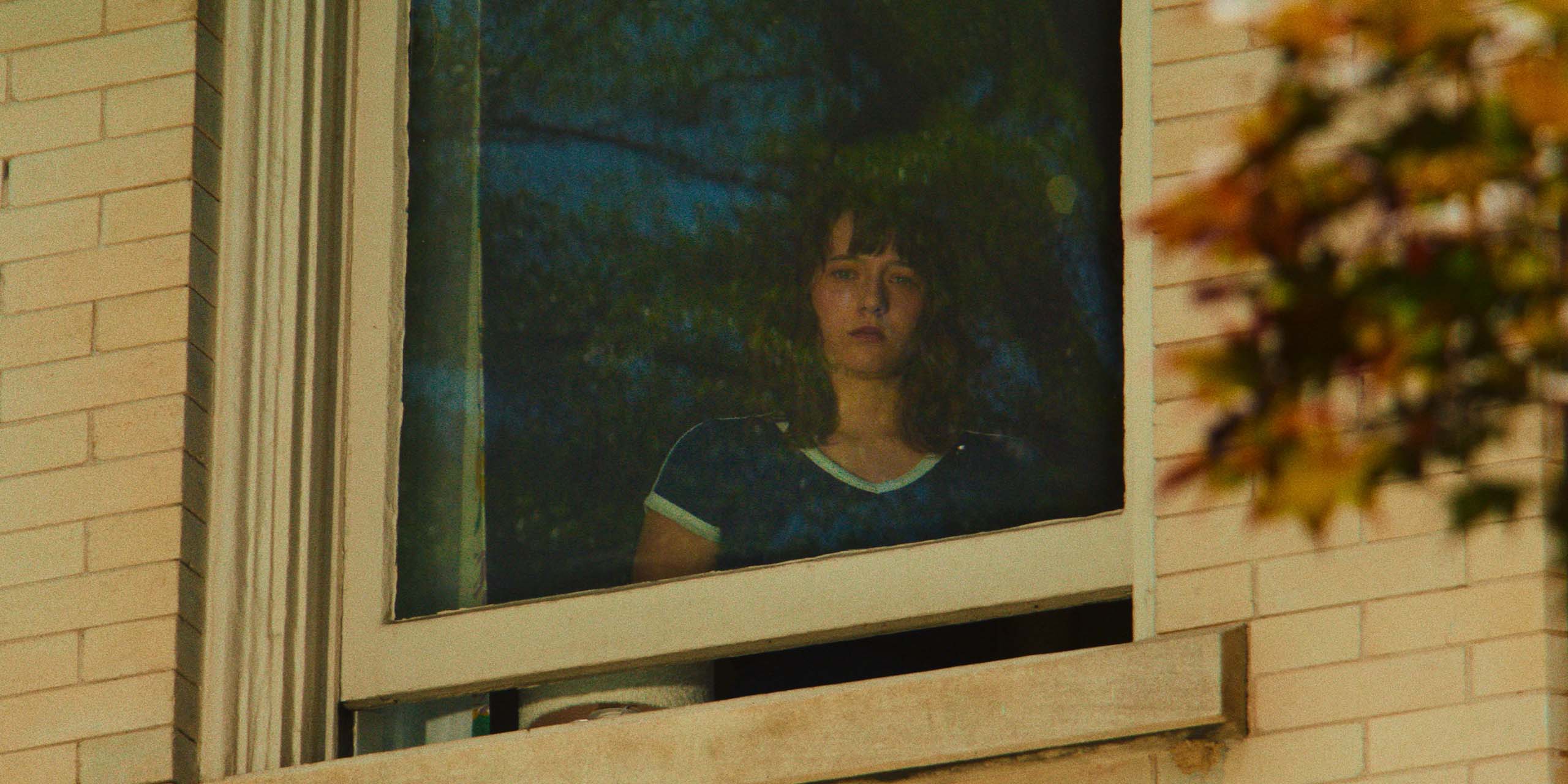 Lily Collias regarde à travers la fenêtre de sa chambre dans Cape Fear - Les Nerfs à vif