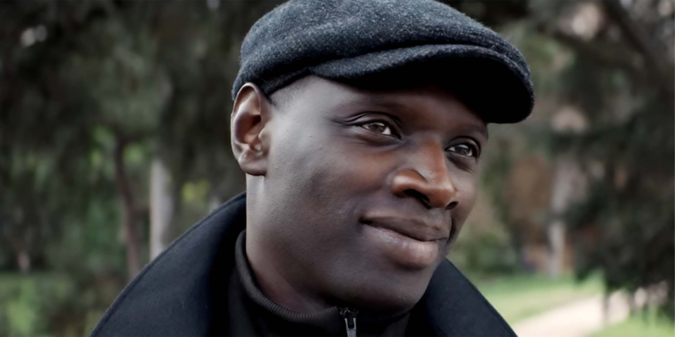 Assane (Omar Sy) sourit dans la saison 2 de Lupin