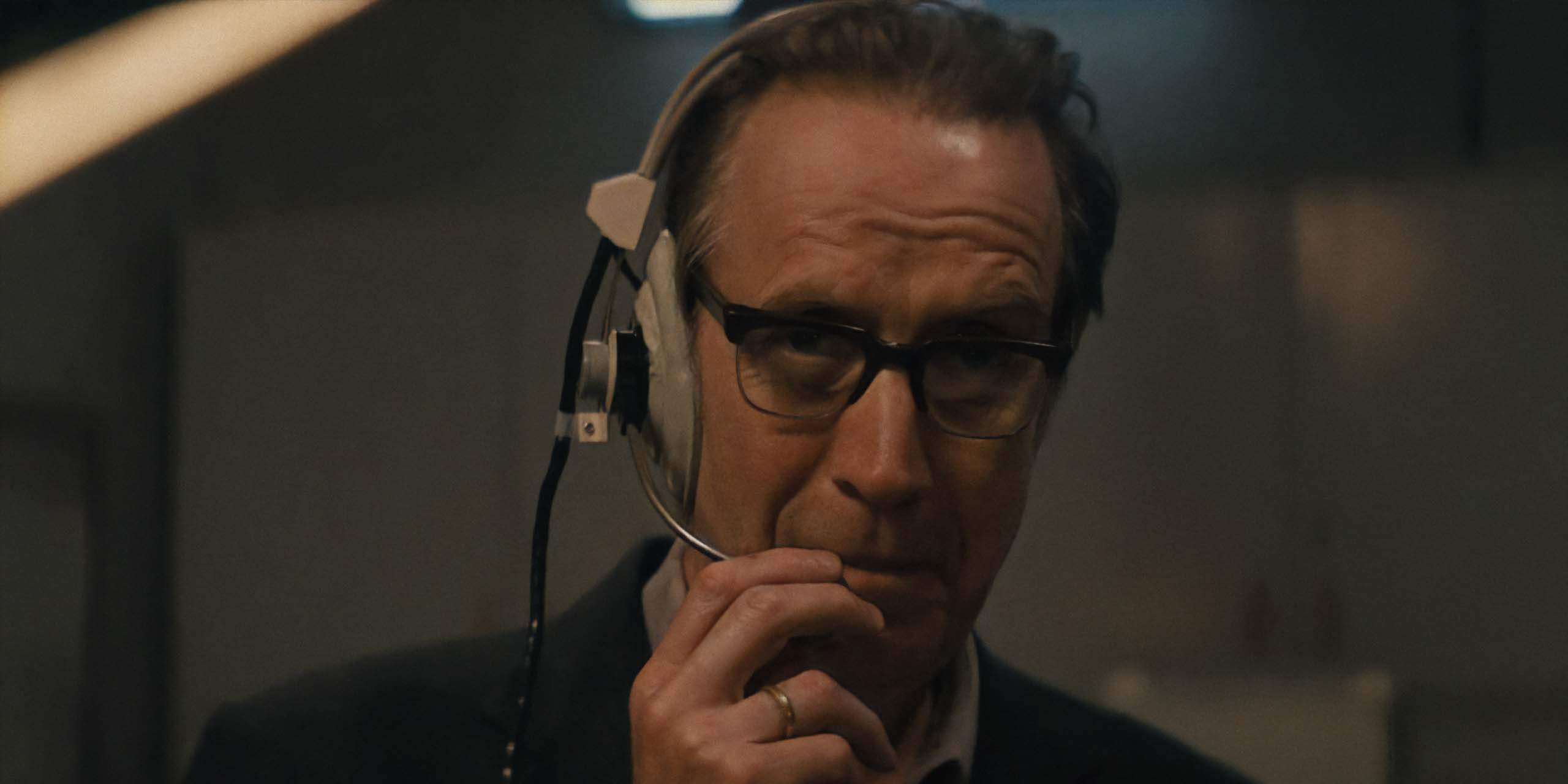 Le Chief Designer (Rhys Ifans) en communication dans Star City.