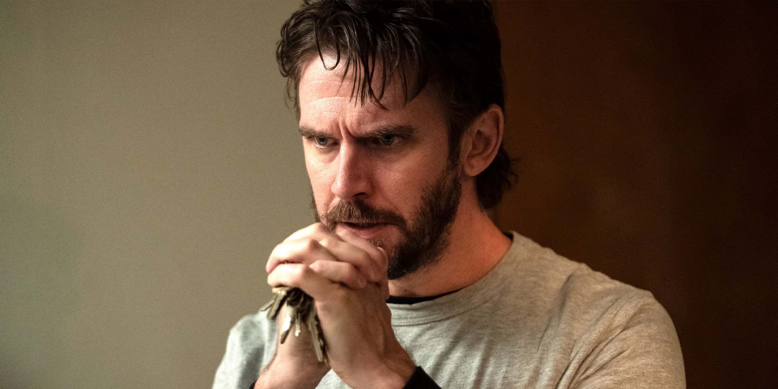 Dan Stevens, dans le rôle de Pepper, le regard intense, joint les mains tenant des clés dans The Terror : The Devil in Silver.