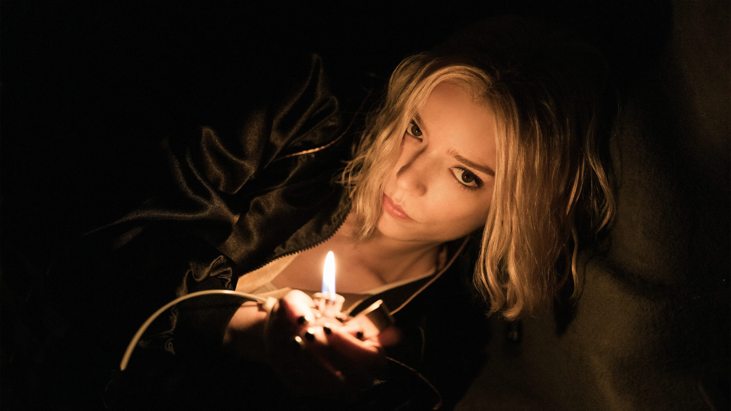 Anya Taylor-Joy dans le rôle de Luciana 'Lucky' Armstrong allume la flamme d'un briquet dans Lucky.