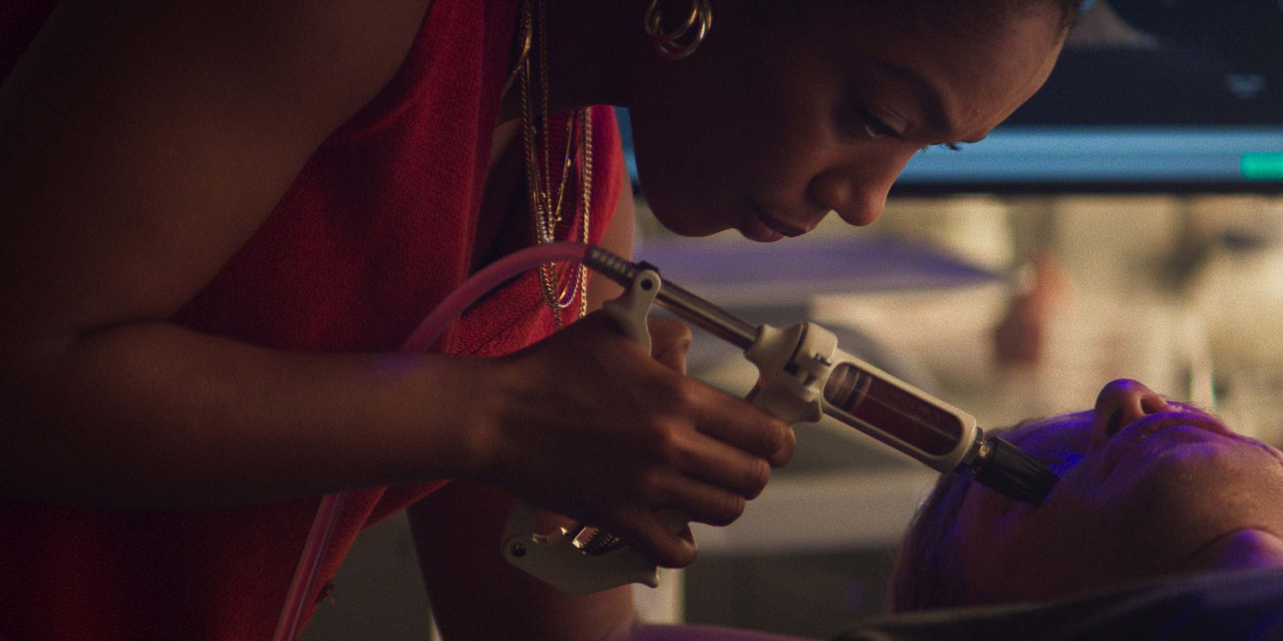 La scientifique Caitlyn Corr (Naomi Ackie) injecte le produit dans le visage de Matt Hagen (Tom Rhys Harries) dans le film Clayface.