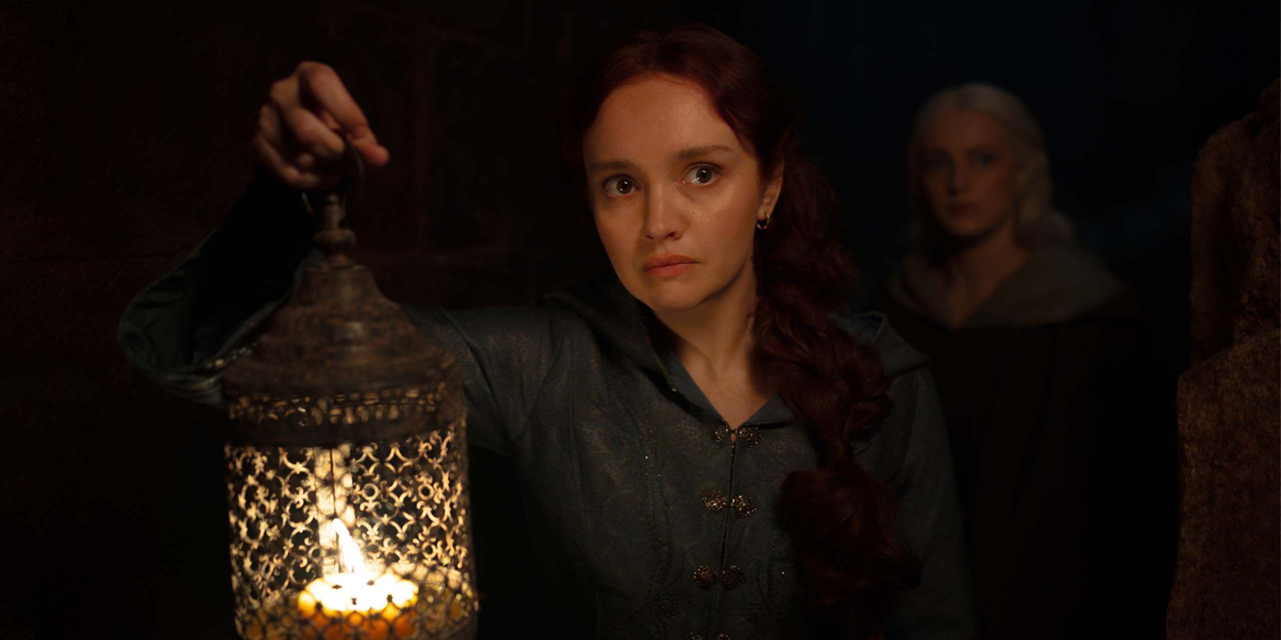 Alicent Hightower (Olivia Cooke) portant une lanterne suivie d'Helaena Targaryen (Phia Saban) dans la saison 3 de House of the Dragon.