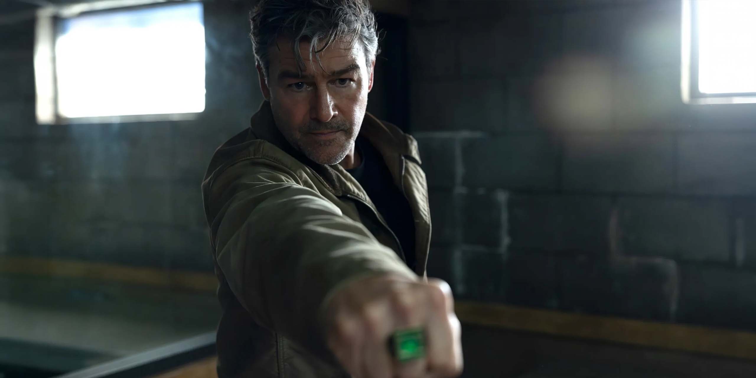 Kyle Chandler dans le rôle de Hal Jordan, pointant son anneau de Green Lantern dans Lanterns