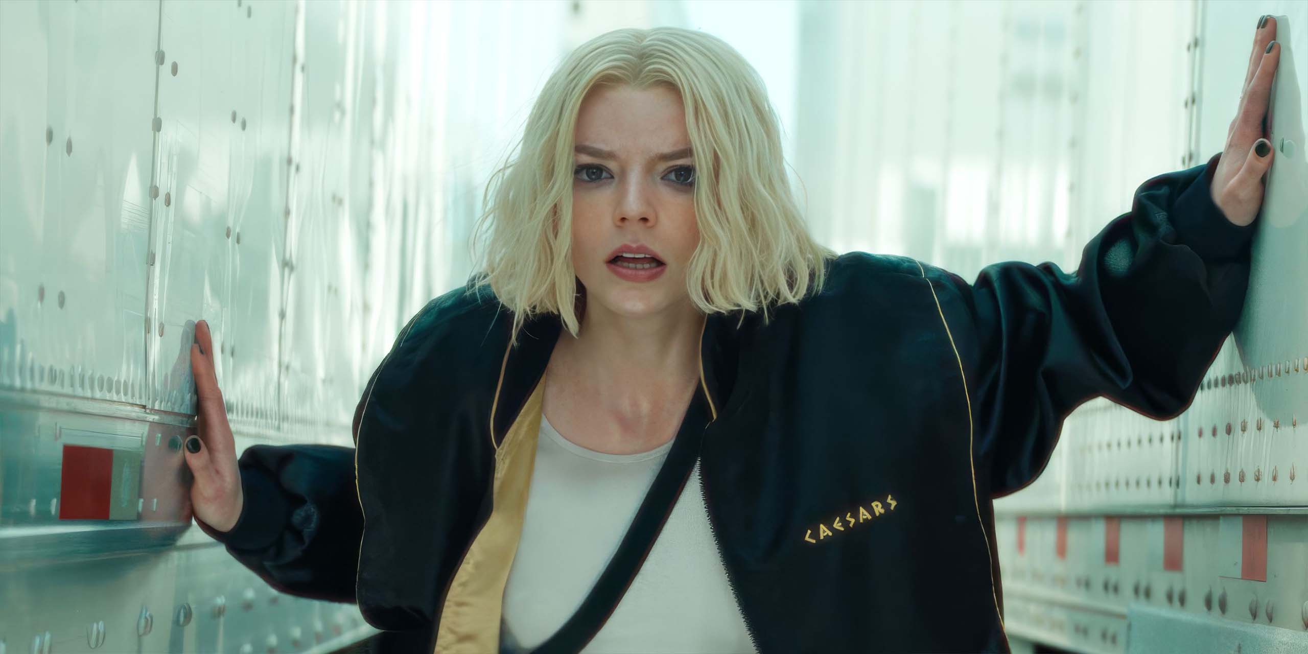 Anya Taylor-Joy cachée entre les remorques de deux camions dans Lucky.