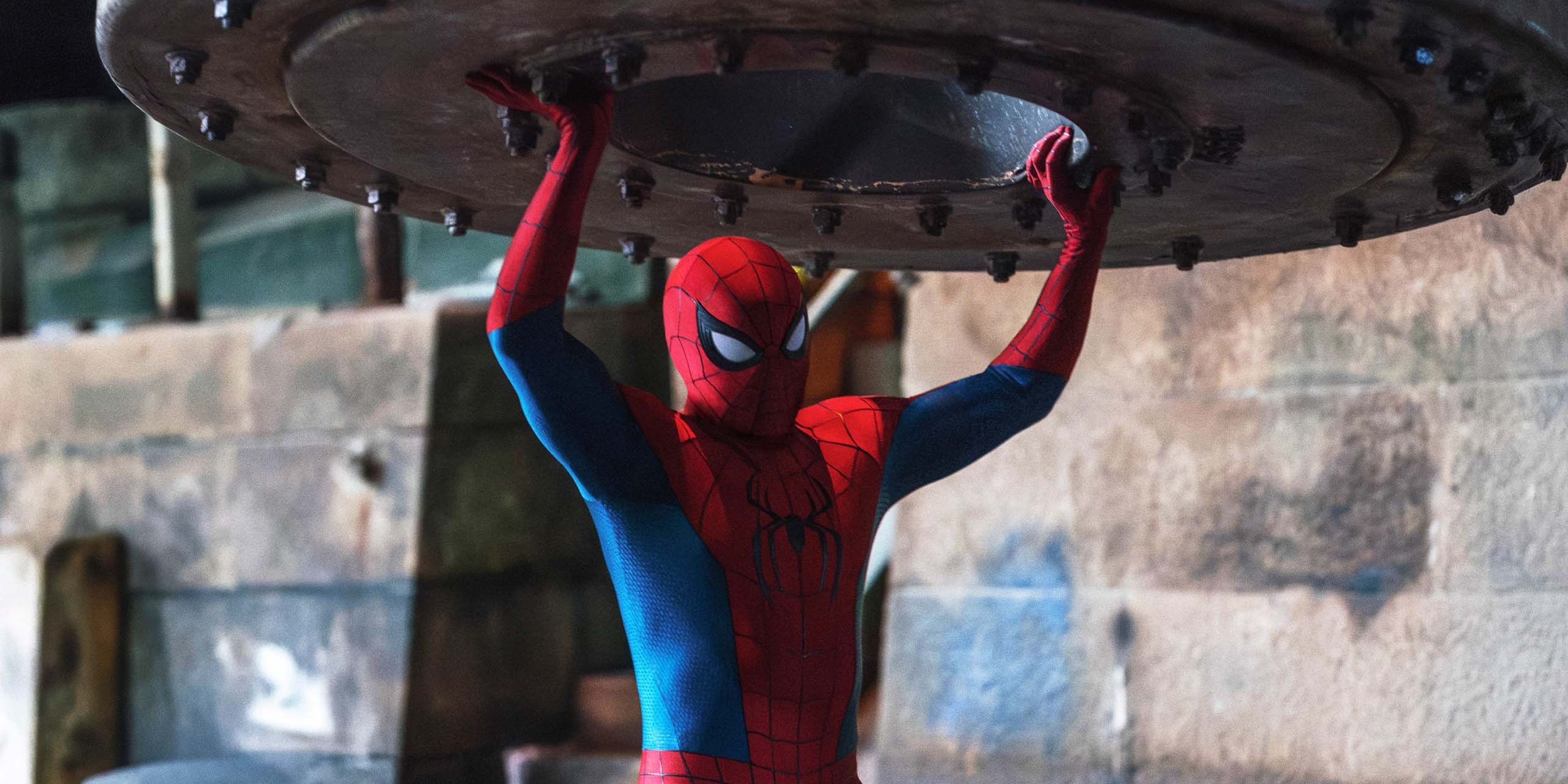 Spider-Man (Tom Holland) soulève une grande pièce en métal dans Spider-Man: Brand New Day.