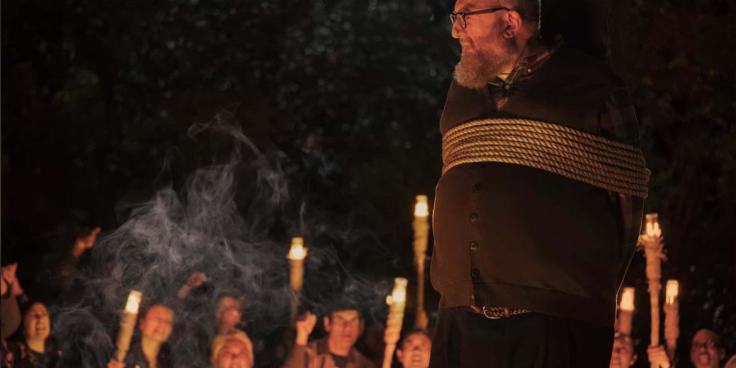 Bert (Brian Posehn) attaché à un poteau face à une foule hostile dans la saison 1 de Stuart Fails to Save the Universe